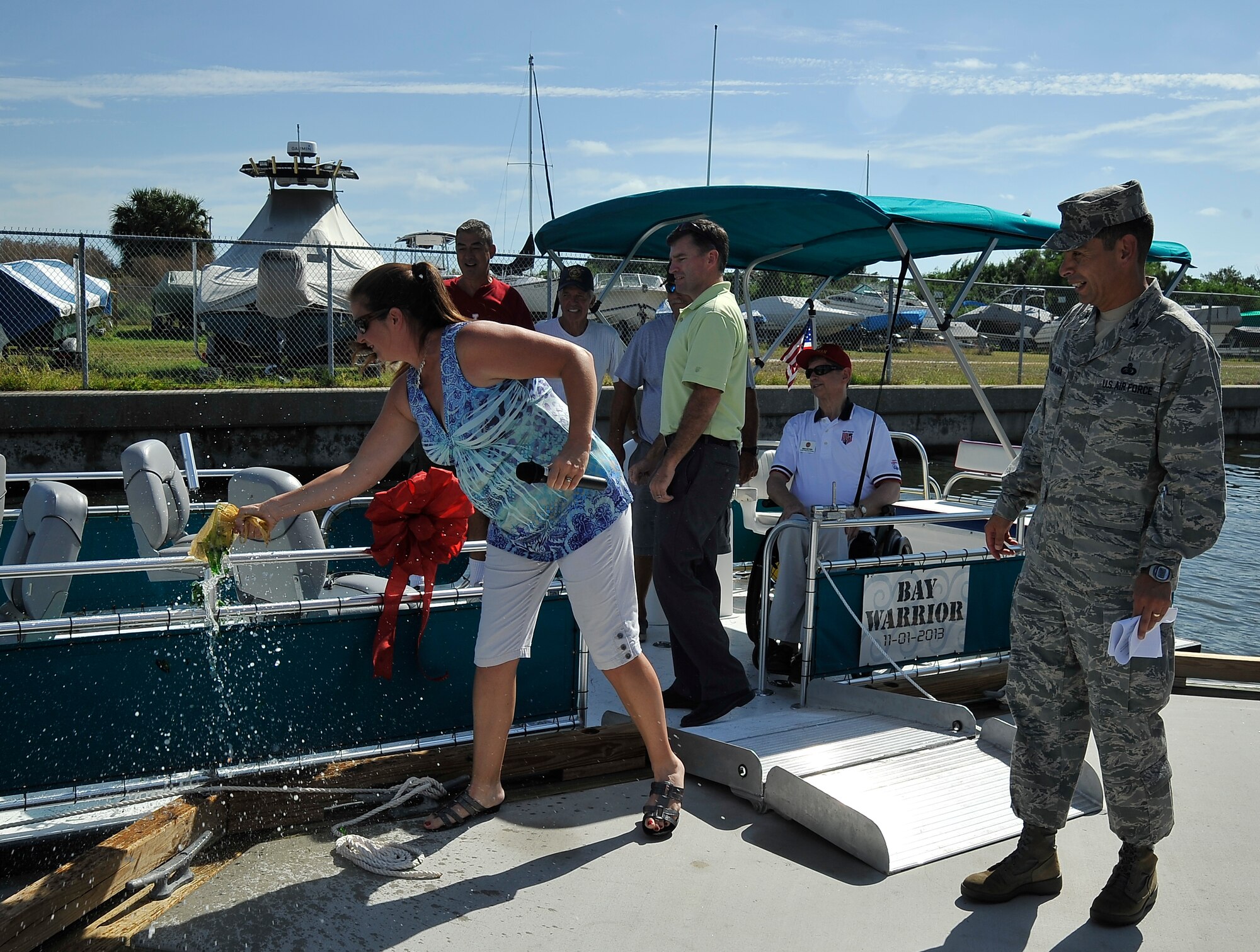 Monica Santa Ana, 6th Mission Support Group commander’s wife, christens the newest boat in MacDill Air Force Base, Fla.’s fleet as the “Bay Warrior” on Nov. 1, 2013. The boat is outfitted with a ramp and tie-downs to accommodate the needs of wounded warriors and their families wishing to enjoy the outdoors. (U.S. Air Force photo by Airman 1st Class Sarah Hall-Kirchner)