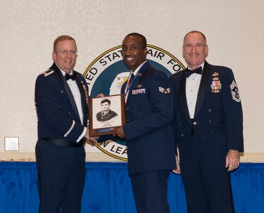 Col. Jeffrey DeVore, Joint Base Charleston commander, and Chief Master Sgt. Earl Hannon, 628th Air Base Wing command chief, present Senior Airman Aaron Williams, 437th Aerial Port Squadron passenger terminal specialist, the John Levitow Award during the Airman Leadership School Class 13-G graduation ceremony October 24, 2013, at JB Charleston - Air Base, S.C. The Levitow Award is awarded for a student's exemplary demonstration of excellence, both as a leader and scholar. (U.S. Air Force photo/Senior Airman Ashlee Galloway)