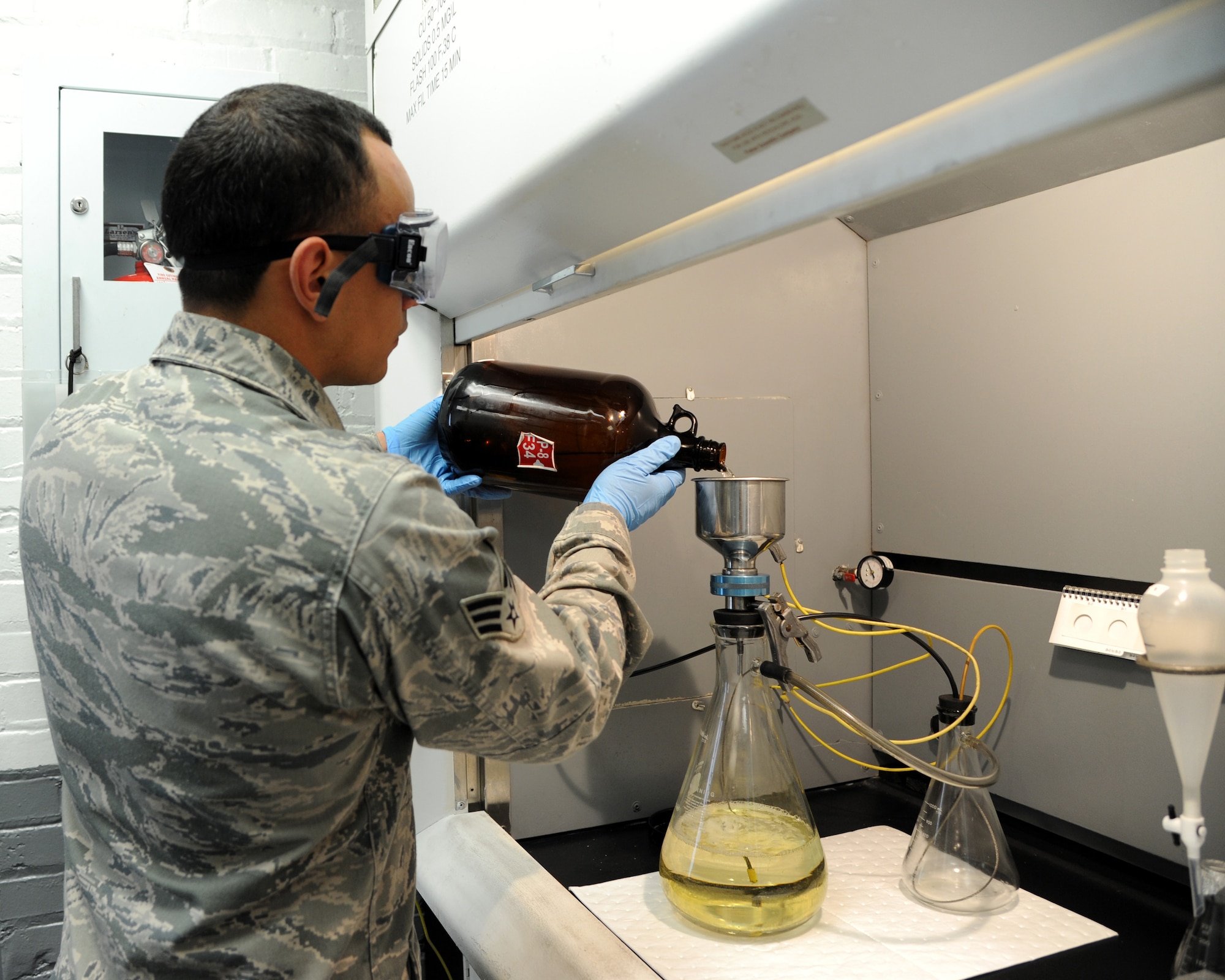 Senior Airman Christian Ramirez, 2nd Logistics Readiness Squadron fuels laboratory technician, pours fuel into a microanalysis filter holder assembly on Barksdale Air Force Base, La., Nov. 5, 2013. Ramirez is sampling fuel from a pipeline that enters the base from underground. The process is used to check how much particles are in a gallon of fuel. (U.S. Air Force photo/Senior Airman Joseph A. Pagán Jr.)