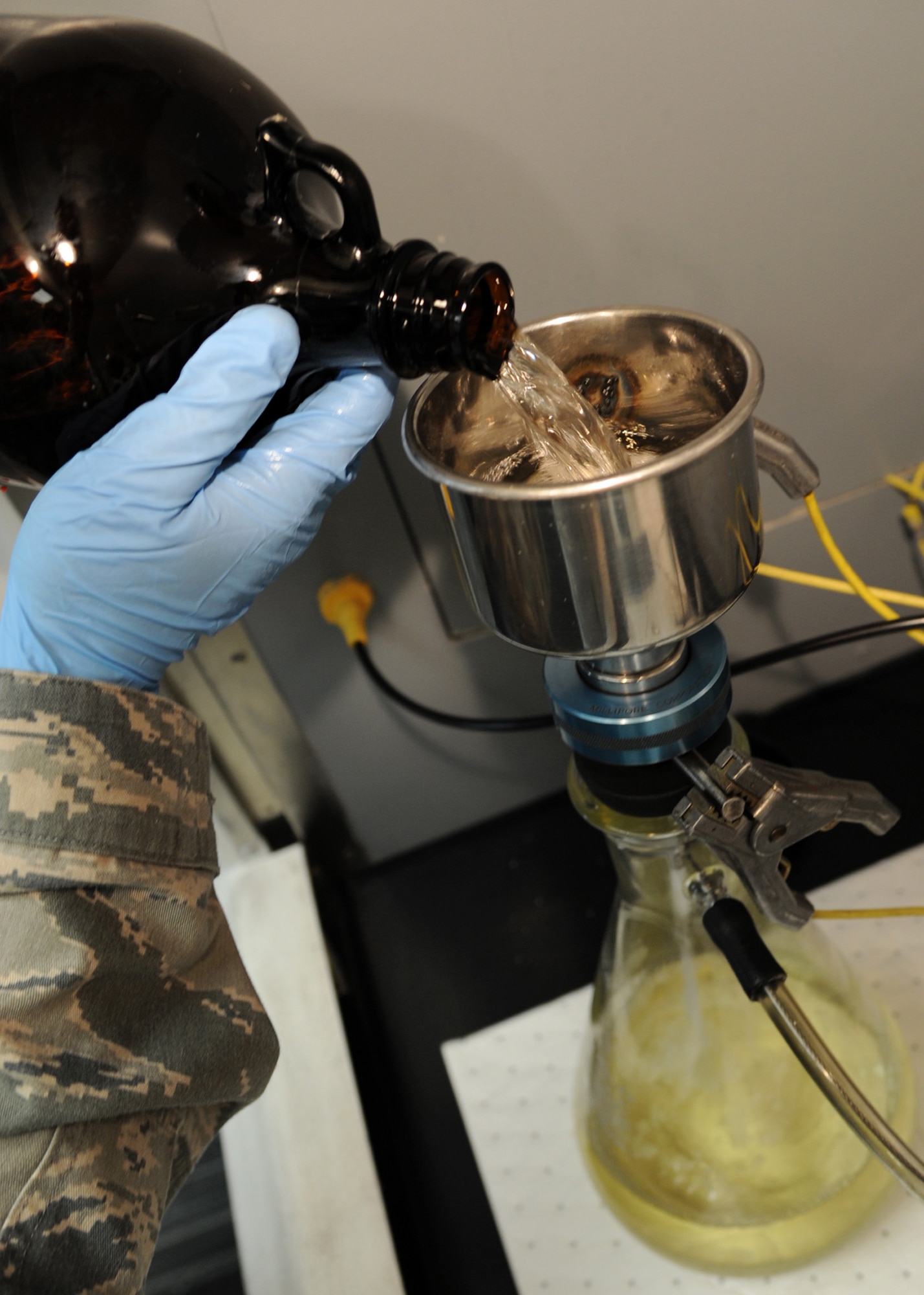Senior Airman Christian Ramirez, 2nd Logistics Readiness Squadron fuels laboratory technician, pours fuel into a microanalysis filter holder assembly on Barksdale Air Force Base, La., Nov. 5, 2013. The assembly creates a vacuum seal in the flask pulling the fuel through a membrane filter leaving behind particles for analysis. (U.S. Air Force photo/Senior Airman Joseph A. Pagán Jr.)