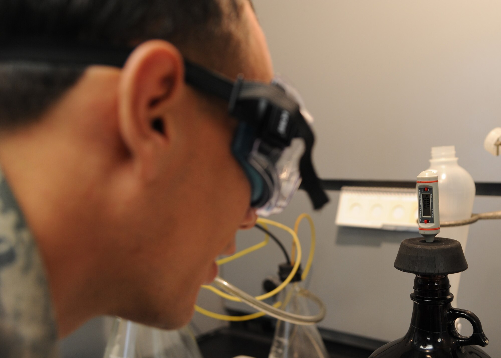Senior Airman Christian Ramirez, 2nd Logistics Readiness Squadron fuels laboratory technician, takes a temperature reading of a fuel sample on Barksdale Air Force Base, La., Nov. 5, 2013. Ramirez used a thermometer to test a fuel sample to ensure the temperature is within the parameters set to run the particulate test. (U.S. Air Force photo/Senior Airman Joseph A. Pagán Jr.)
