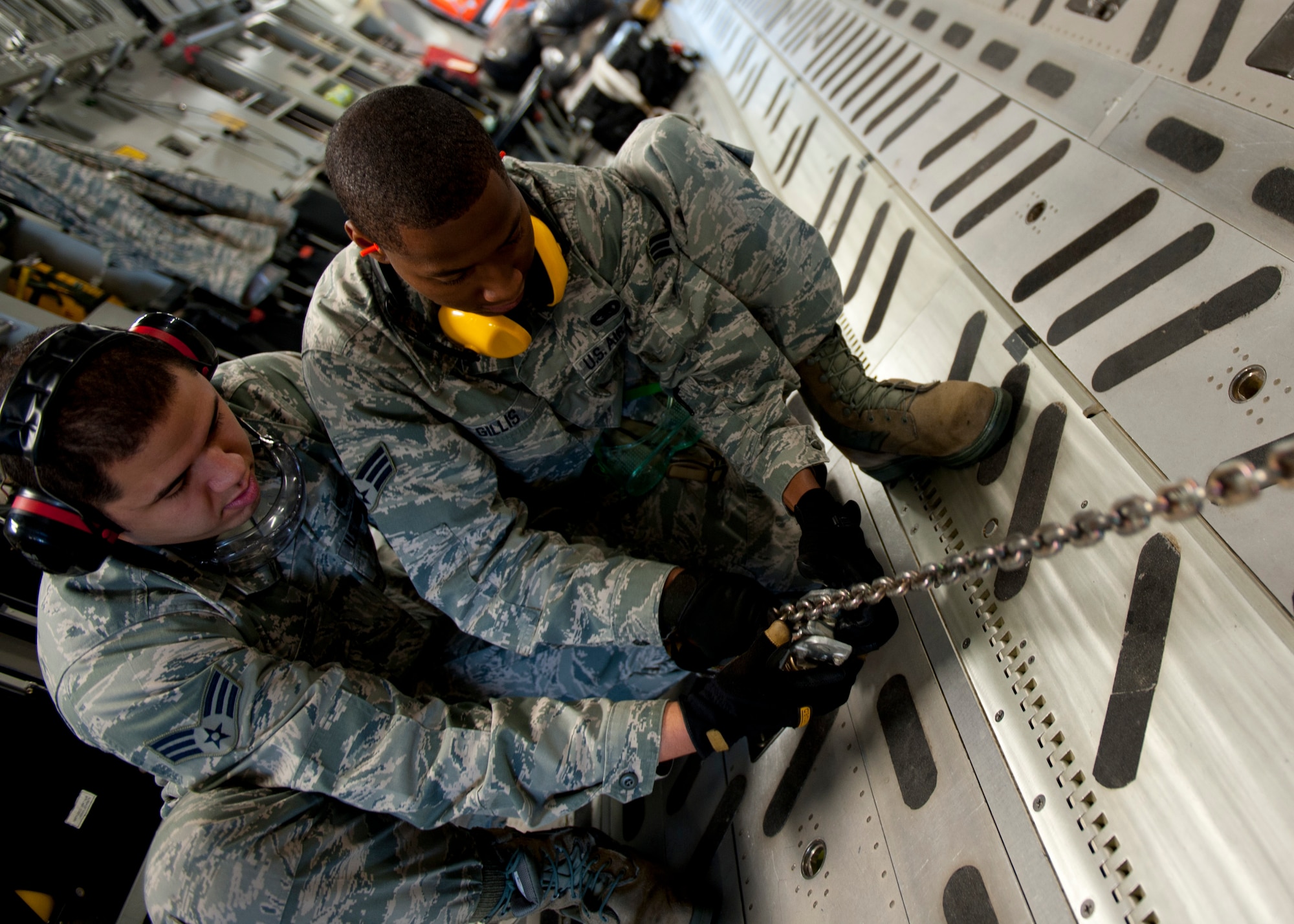 U.S. Air Force Senior Airmen Randall Gillis and Barry Christian, 71st Aerial Port Squadron ramp specialists, chain down a truck inside a C-17 Globemaster III during a training mission at Langley Air Force Base, Va., Nov. 2, 2013. Though stationed at Langley AFB, the 71st APS is a geographically-separated Air Force Reserve unit of the 512th Airlift Wing, located at Dover AFB, Del. (U.S. Air Force photo by Staff Sgt. John D. Strong II/Released)