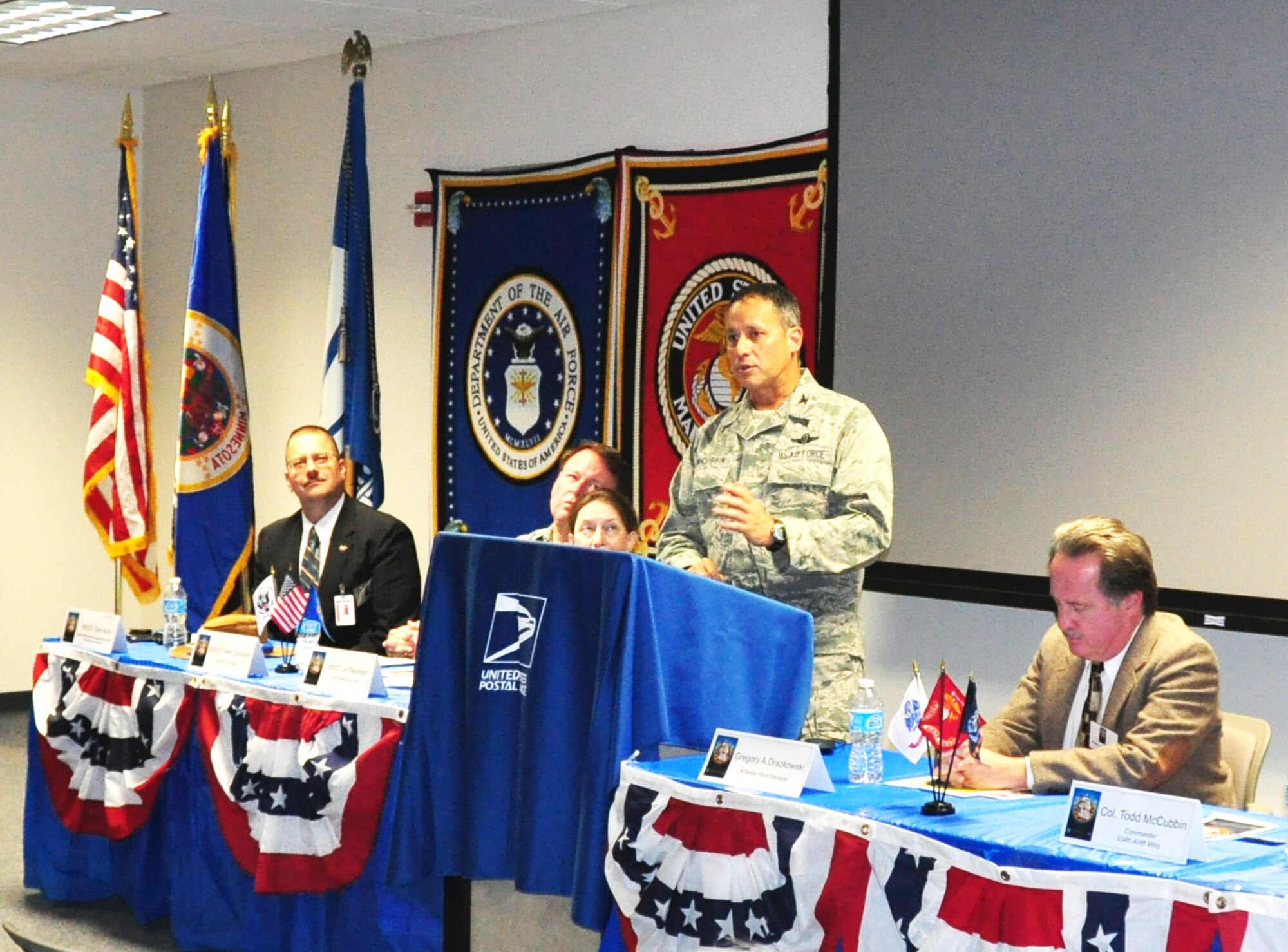 Col. Todd J. McCubbin, 934th Airlift Wing commander, speaks at the U.S. Post Office Tribute to Veterans ceremony Nov. 5.  Master Sgt. (ret) Lin Davidson, Senior Master Sgt. (ret) Mark Davidson and  Master Sgt. Dan Roth from the 934th AW also spoke about some of  their deployment experiences to an audience of Post Office employees and veterans.   (Air Force Photo/Paul Zadach)