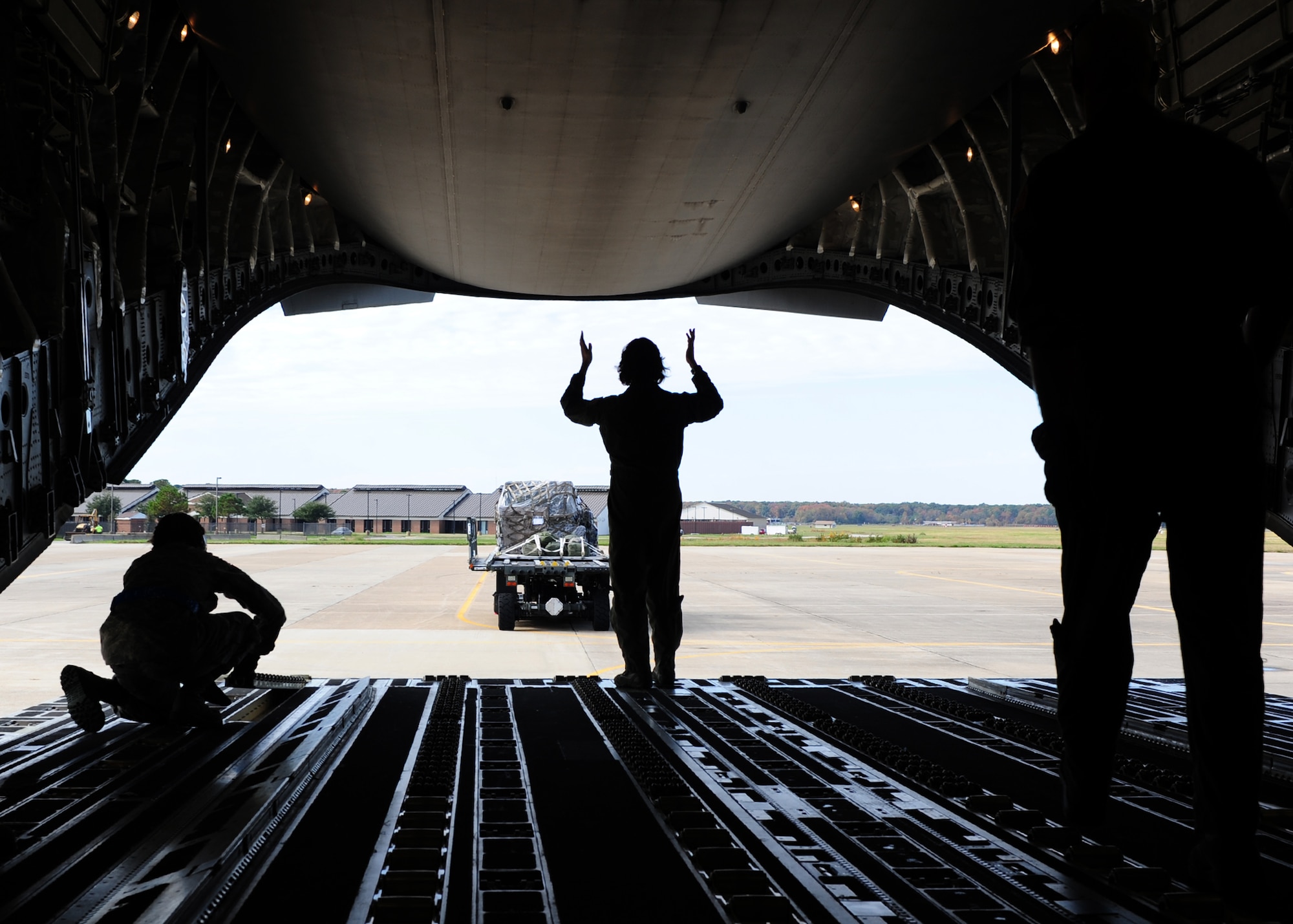 U.S. Air Force Master Sgt. Michelle Hite, 326th Air Lift Squadron loadmaster, directs a K loader as it approaches a C-17 Globemaster III during a training exercise hosted by the 71st Aerial Port Squadron at Langley Air Force Base, Va., Nov. 2, 2013. Loadmasters ensure cargo is specifically placed on the aircraft to prevent overloading sections of the airframe and cargo floor. (U.S. Air Force photo by Airman Areca T. Wilson/Released)
