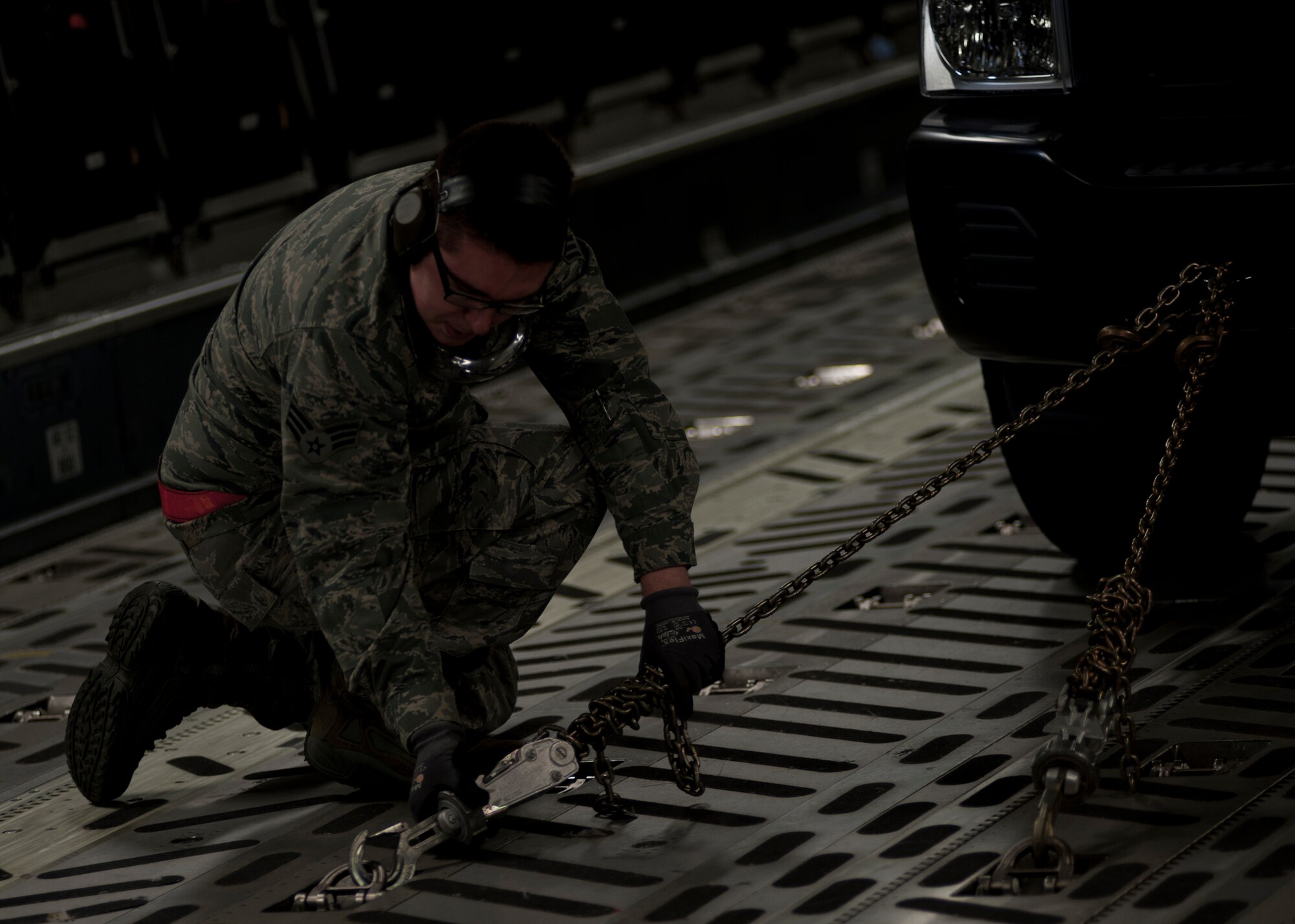 U.S. Air Force Senior Airman Derek Miller, 71st Aerial Port Squadron ramp specialist, secures a truck in a C-17 Globemaster III during a training exercise at Langley Air Force Base, Va., Nov. 2, 2013. Though stationed at Langley AFB, the 71st APS is a geographically-separated Air Force Reserve unit of the 512th Airlift Wing, located at Dover AFB, Del. (U.S. Air Force photo by Airman Areca T. Wilson/Released)