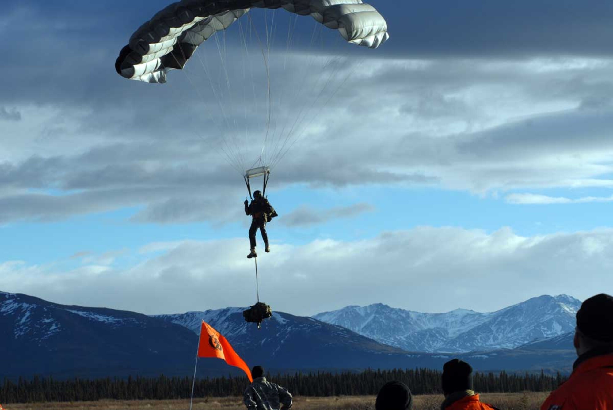 A pararescue jumper approaches the ground after jumping out of a plane over Donnelly Training Area, Oct. 30. The soldier is part of the Joint Task Force-Alaska, Alaska National Guard, U.S. Army Alaska, Canadian Joint Operations Command, Arctic Search and Rescue Exercise held here and at Joint Base Elmendorf-Richardson. Canadian and U.S. Search and Rescue assets jumped into the simulated crash site and immediately began stabilizing and providing treatment to the wounded until support was available to transport the wounded to a medical treatment facility. This exercise aimed to increase the collective interoperability between the U.S. and Canada. (Photo by U.S. Army public affairs)