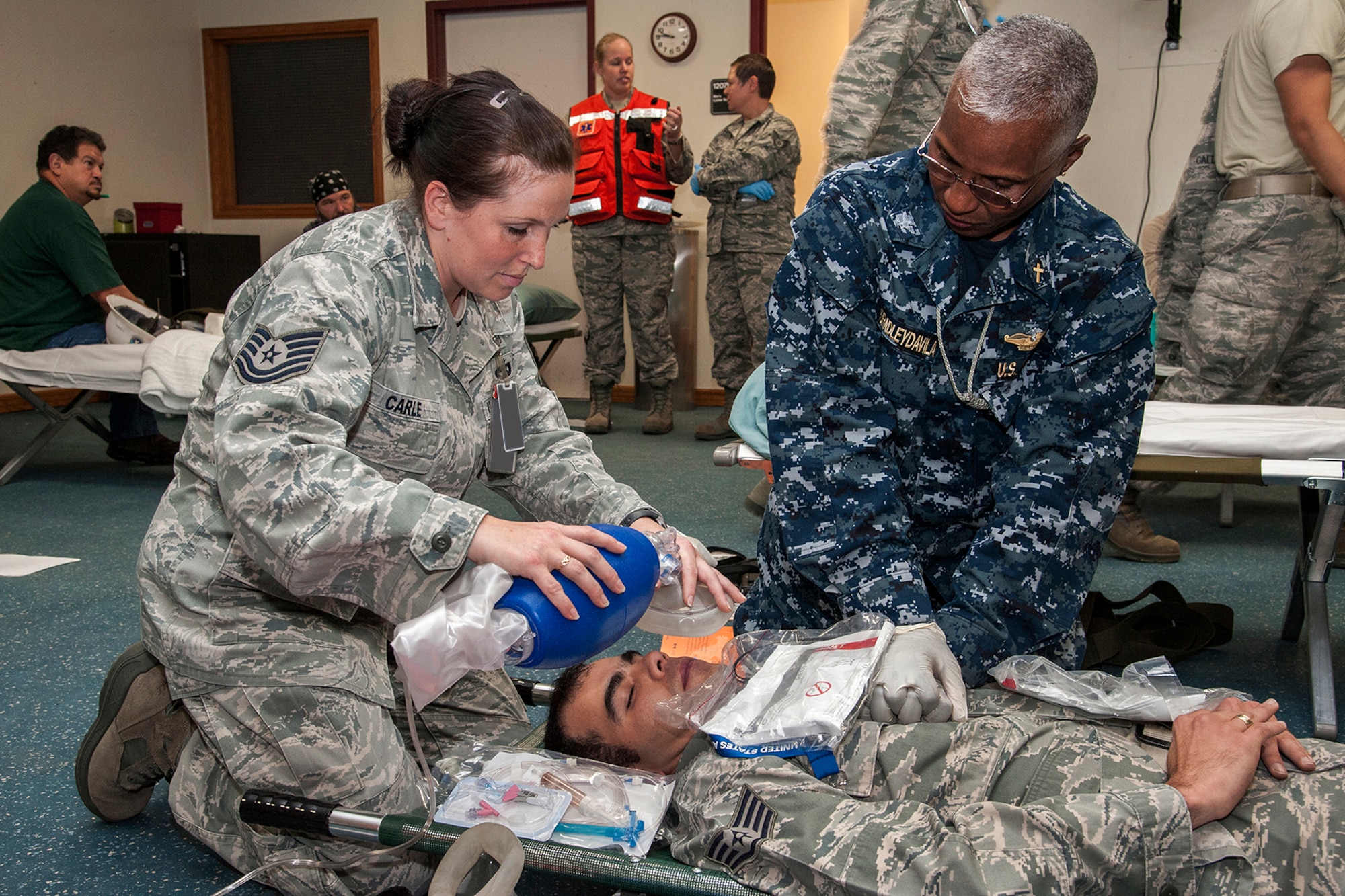 CHEYENNE MOUNTAIN AIR FORCE STATION, Colo. -- Navy Capt. Brenda BradleyDavila, NORAD/NORTHCOM command chaplain, and Tech. Sgt. Lerinda Carle, 21st Medical Operations Squadron, perform simulated CPR on Staff Sgt. Alex Gaviria, 721st Communications Squadron, during the Vigilant Shield Exercise at Cheyenne Mountain AFS. This realistic training was part of the Vigilant Shield exercise designed to keep Cheyenne Mountain personnel prepared for a real world incident. (U.S. Air Force photo/Craig Denton)