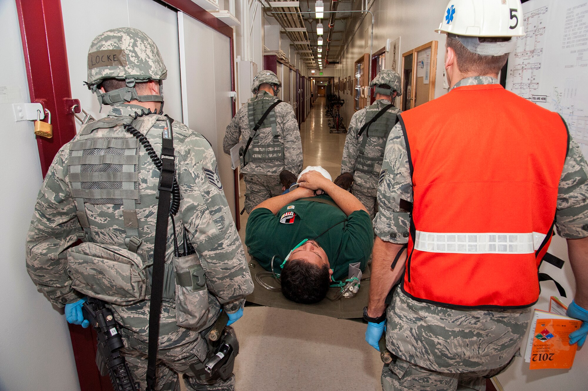 CHEYENNE MOUNTAIN AIR FORCE STATION, Colo. -- Members of the 721st Security Forces Squadron and Medical Response Team move Arthur Rivera, 721st Civil Engineer Squadron, to the Cheyenne Mountain clinic for treatment. This realistic training was part of the Vigilant Shield exercise designed to keep Cheyenne Mountain personnel prepared for a real world incident. (U.S. Air Force photo/Craig Denton)