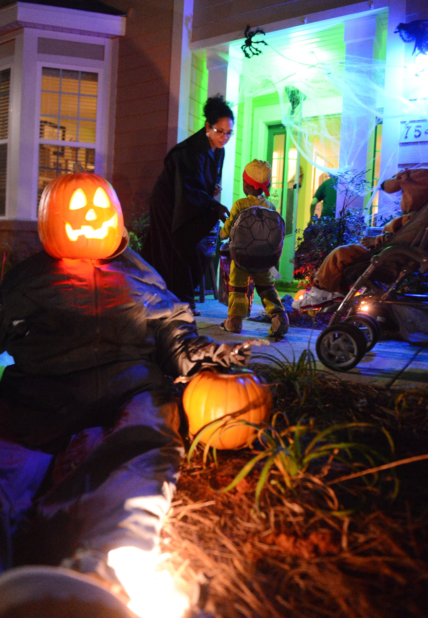 A Team Shaw spouse passes out candy to children at Shaw Air Force Base, S.C., Oct. 31, 2013. In addition to a week of Halloween-themed events offered on base, base-housing residents welcomed hundreds of trick-or-treaters Halloween night. (U.S. Air Force photo by Senior Airman Tabatha Zarrella/Released)
