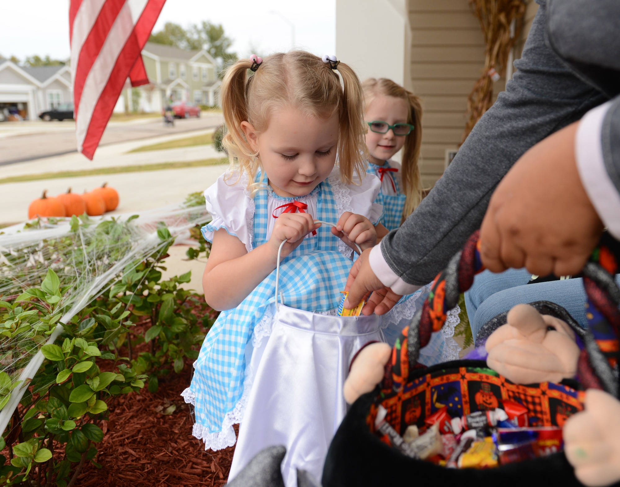 Sara, 4, and Kyleigh, 4, choose treat over trick while going door-to-door during Halloween, Shaw Air Force Base, S.C., Oct. 31, 2013. In addition to a week of Halloween-themed events offered on base, base-housing residents welcomed hundreds of trick-or-treaters Halloween night. (U.S. Air Force photo by Senior Airman Tabatha Zarrella/Released)
