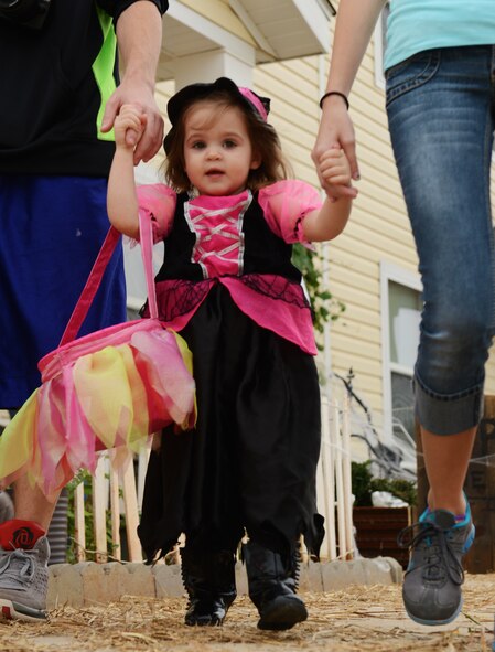 Sage, 2, goes trick-or-treating with her family and friends at Shaw Air Force Base, S.C., Oct. 31, 2013. Trick-or-treaters filled the streets of base housing neighborhoods Halloween night, visiting houses in various costumes and gathering treats. (U.S. Air Force photo by Senior Airman Tabatha Zarrella/Released)