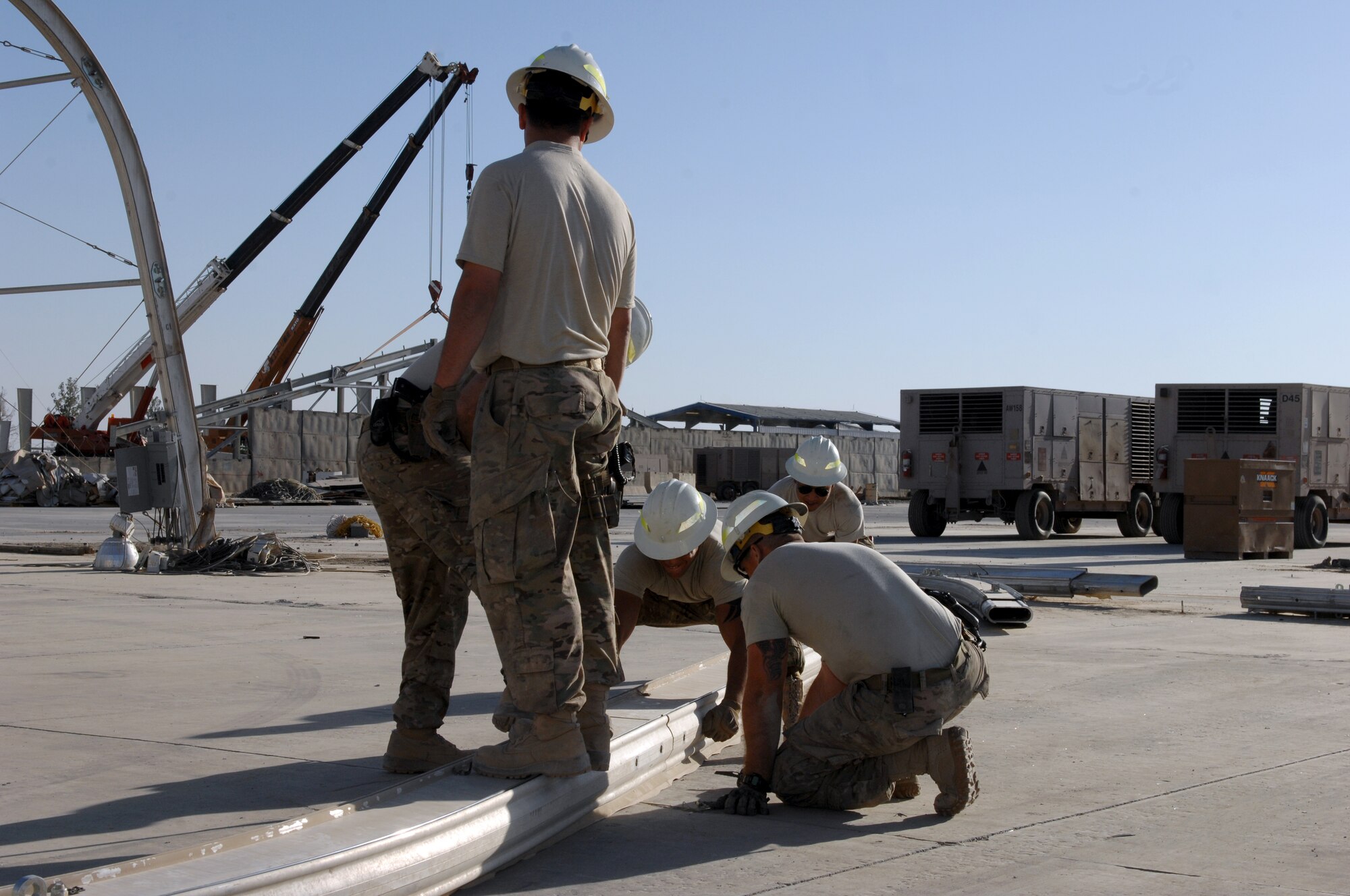 Members of the 577th Expeditionary Civil Engineer Squadron PRIME BEEF disassemble beams to a hangar Oct. 31, 2013, at Kandahar Airfield, Afghanistan. Service members teamed up to help with the retrograde of the Golf ramp here. (U.S. Air Force photo by Senior Airman Jack Sanders)
