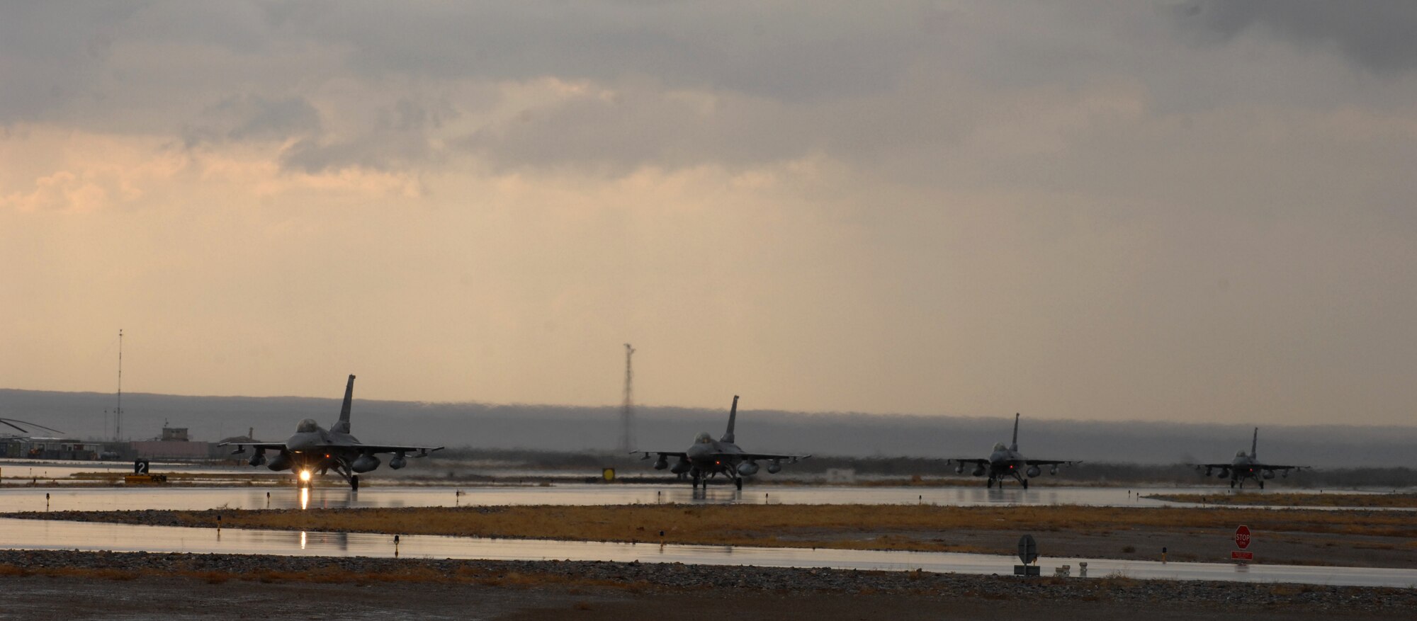 F-16 Fighting Falcons taxi at Kandahar Airfield, Afghanistan, Nov. 5, 2013. The aircraft are part of the changeover between the 457th Fighter Squadron, Carswell, Texas, and the 138th Fighter Squadron, Tulsa, Okla. (U.S. Air Force photo by Senior Airman Jack Sanders)