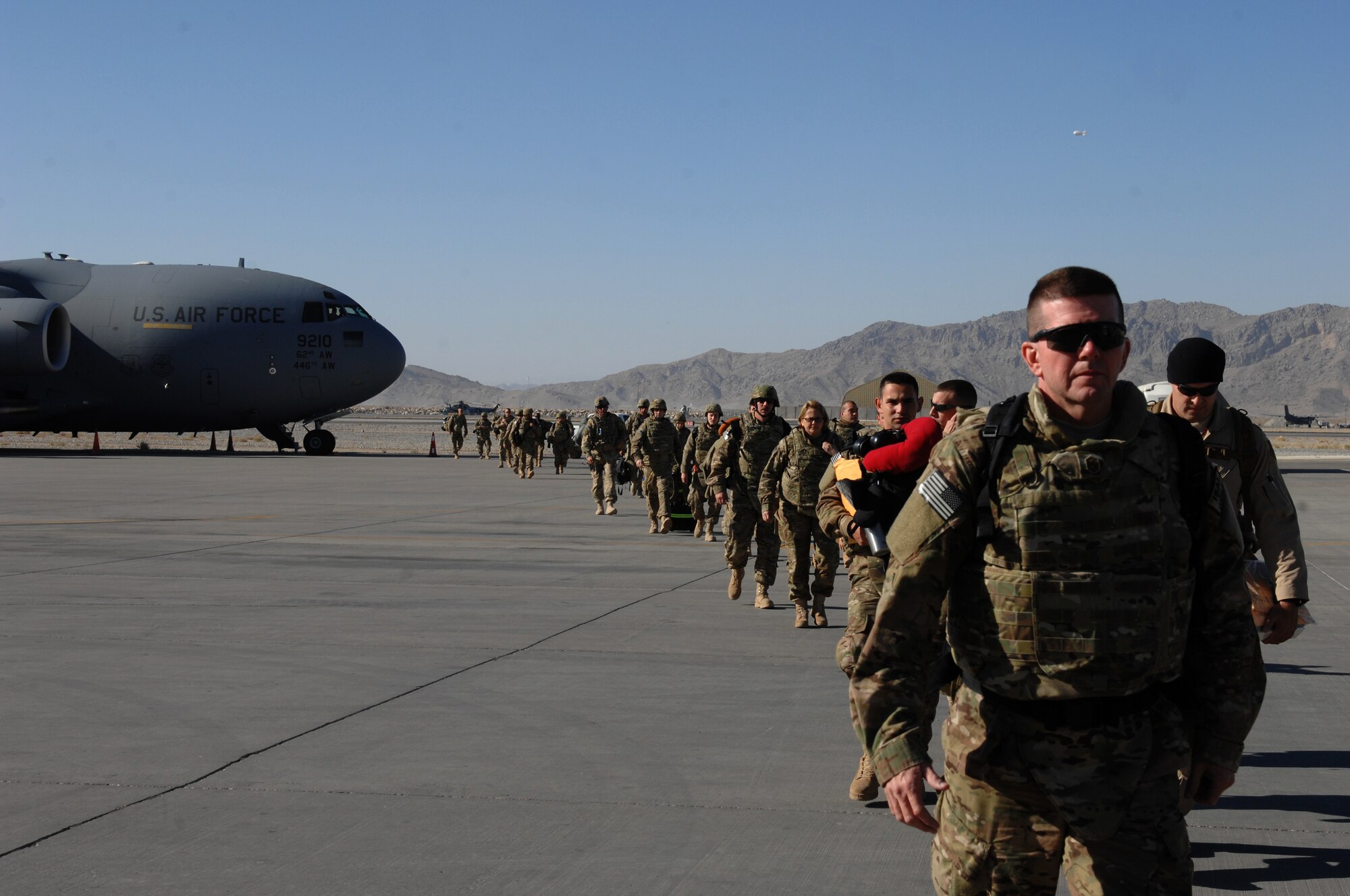 Airmen from the 457th Fighter Squadron, Carswell, Texas, walk on the flightline after unloading from a C-17 Globemaster III at Kandahar Airfield, Afghanistan, Nov. 1, 2013. New arrivals are briefed at the passenger terminal before arriving at their units for change-over briefings. (U.S. Air Force photo by Senior Airman Jack Sanders)