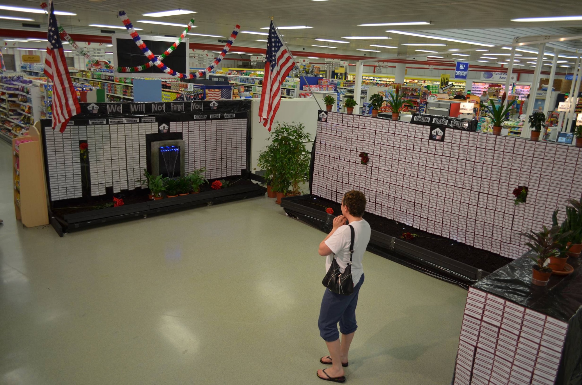BITBURG BASE ANNEX, Germany --- A shopper reviews a “Hall of Heroes” display commemorating the 10th anniversary of 9/11 as she shops at the Bitburg Base Annex Commissary in this September 2011 photo. The commissary ceased operations Oct. 31, 2013. (Courtesy photo)