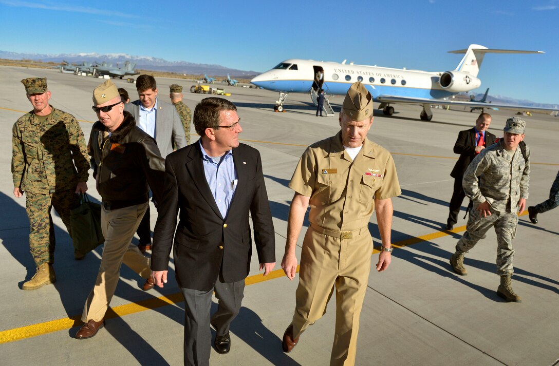 Deputy Defense Secretary Ash Carter, center left, talks with Navy Capt. Keith Davis following his arrival on Naval Air Station Fallon, Nev., Nov. 5, 2013. 