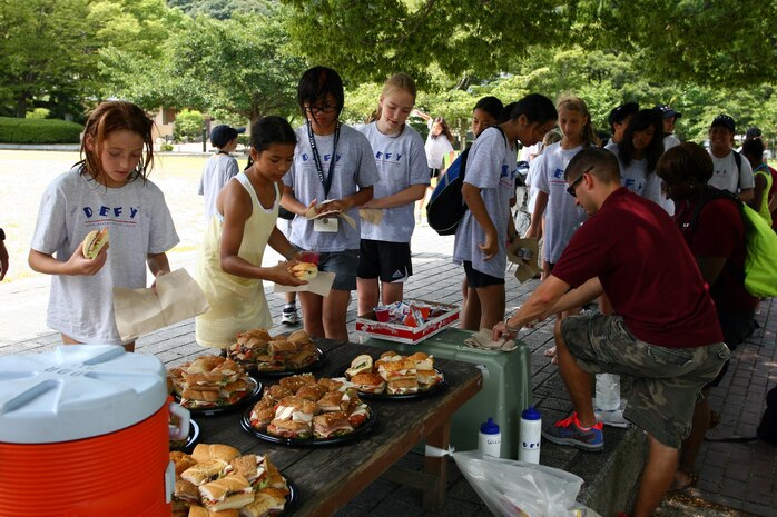 Children from the DEFY program eat sandwiches at Kintai park during a field trip Aug.5. The children are given sandwiches as a healthy alternative to fatty foods. The program shows the kids the importance of eating healthy, exercising and making the right choices.
