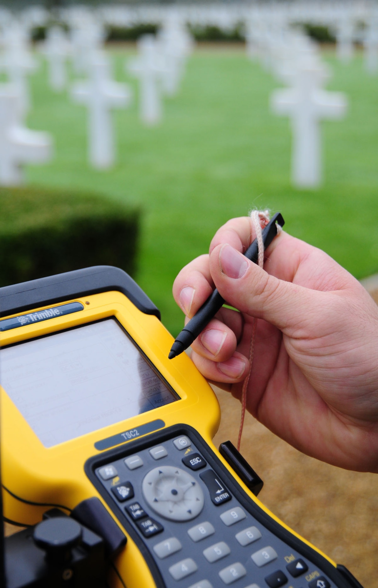 Senior Airman Logan Fountaine uses a data collector to input information and GPS grid coordinates Oct. 16, 2013, located at each headstone in Madingley American Cemetery, near Cambridge, England. The equipment was a base station to collect data from 24 GPS satellites in orbit. All the data from the project will be used to create an electronic map to allow families and friends of those Americans lost in World War II to pinpoint the location of their resting place. Fountaine is a 100th Civil Engineer Squadron engineering flight journeyman.