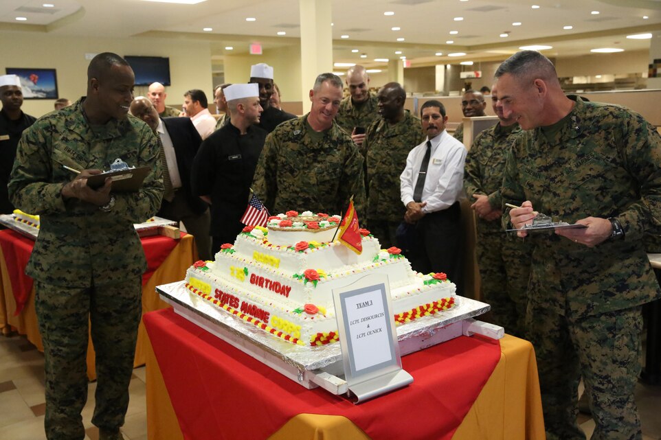 Brigadier Gen. James W. Lukeman, the 2nd Marine Division commanding general, Sgt. Maj. Bryan K. Zickefoose, the 2nd Marine Division sergeant major, and Master Gunnery Sgt. Anthony Butler, the food technician for G-4 Food Services observe a cake during the 2013 Marine Corps birthday cake competition aboard Marine Corps Base Camp Lejeune, Nov. 6, 2013. Food service Marines were tasked with creating a cake for celebrating the Marine Corps’ 238th birthday.