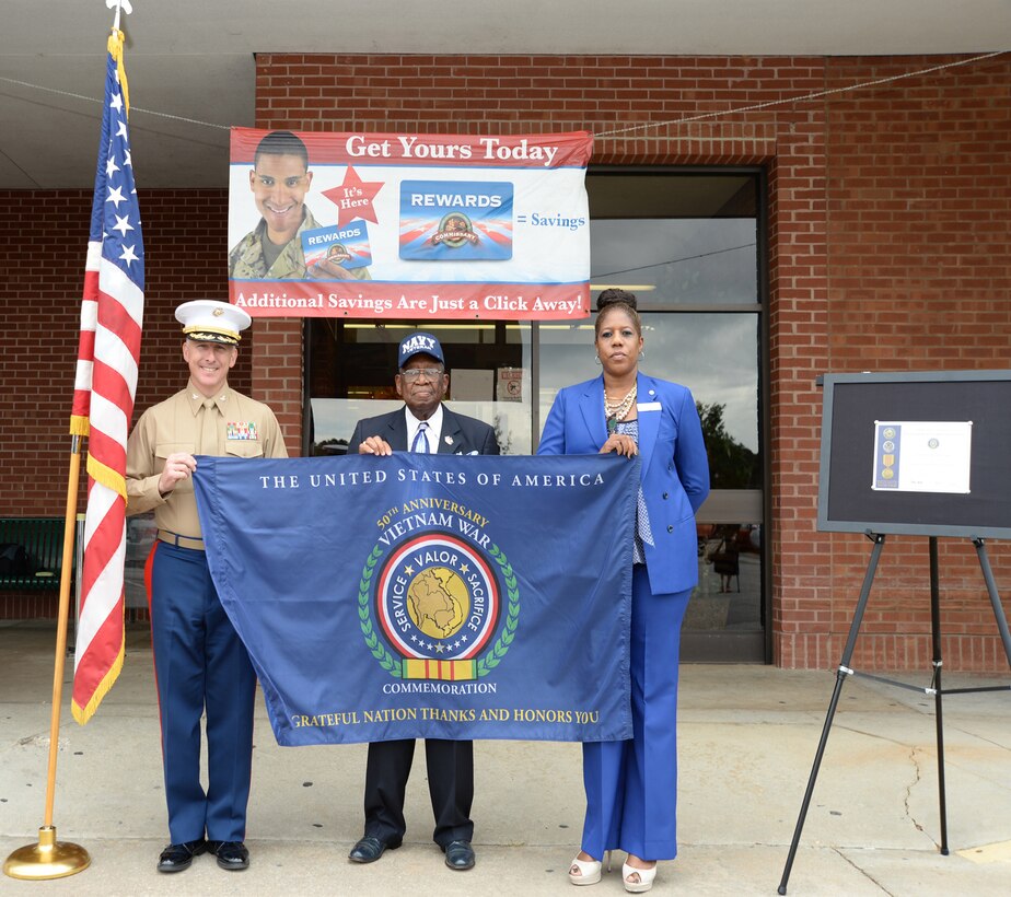 To commemorate the 50th anniversary of the Vietnam War, Defense Commissary Agency became partners of the Vietnam War Veterans Commemorative Partnership Program in March 2013.  
Marine Corps Logistics Base Albany unveiled the newly designed Department of Defense flag during a ceremony in front of its Commissary, today. A decision was made to create a memorial ceremony at each commissary worldwide during the Veterans Day weekend from November 9 - 11, 2013.  
J. D. Armstrong was the honoree at today's ceremony. Armstrong devoted "20 years and one week" of service in the U.S. Navy. After the presentation of the commemorative flag, the base commander, Col. Don J. Davis, thanked him for his service and sacrifice to the country.
