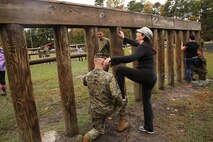 Lt. Col. Jesse A. Kemp, the commanding officer of 2nd Supply Battalion, Combat Logistics Regiment 25, 2nd Marine Logistics Group helps his wife over a wall during an obstacle course aboard Camp Lejeune, N.C., Nov. 7, 2013. The course was one of many activities which spouses of the battalion participated in during a Jane Wayne Day. (U.S. Marine Corps photo by Lance Cpl. Shawn Valosin)