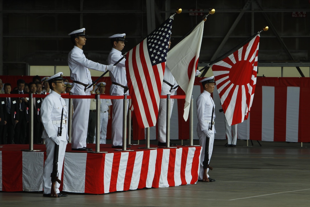 The color guard presents the colors while the Japanese and American national anthems play during the opening ceremony of the Japanese Maritime Self-Defense Force Iwakuni Air Base Festival here Sunday. JMSDF is tasked with the naval defense of Japan.