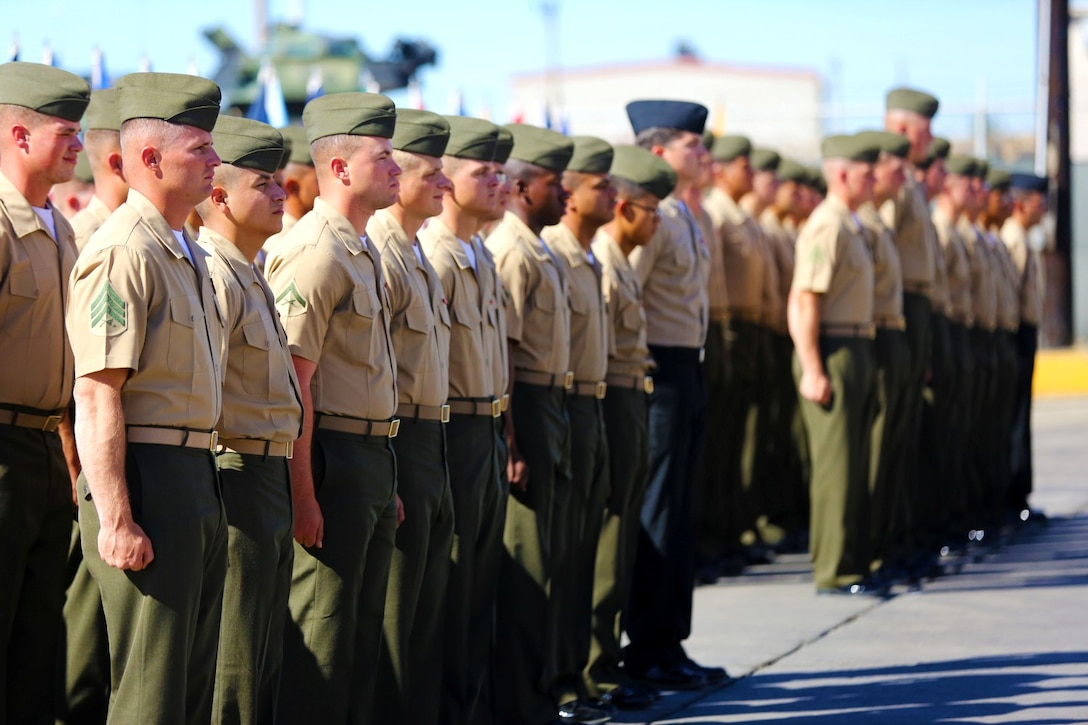 Marines and sailors with Charlie Company, 3rd Assault Amphibian Battalion, stand at attention while the Marines Hymn plays during the company's deactivation ceremony here, Nov. 1, 2013. Captain Matthew Hohl, Charlie Co. commander, said he believes the company will be reactivated when they are needed and this is just a pause in their history. The Marines with Charlie Company will continue to serve the battalion by integrating into Echo Company.