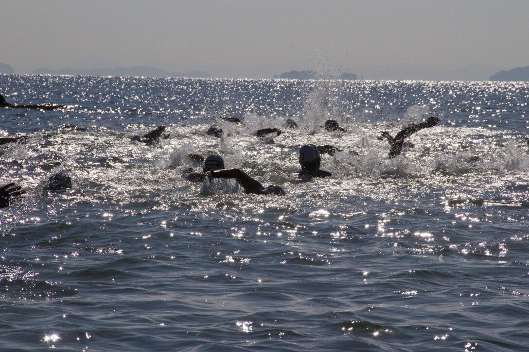 Competitors begin the Marine Corps Community Services Iwakuni Modified Triathlon with a one kilometer swim here Sunday.The swimming portion consisted of two laps out to a buoy and back. The buoy was placed 250 meters away, but with the current and the turn-around point forcing competitors to slow down. 200 participants came out to fight their way through a 1 kilometer swim, a 32k bike ride, and two 4k runs. Many of the participants came from off the station in order to compete in something unique. Many different athletic events occur off base as well as on base giving people an opportunity to compete in teams or relays.