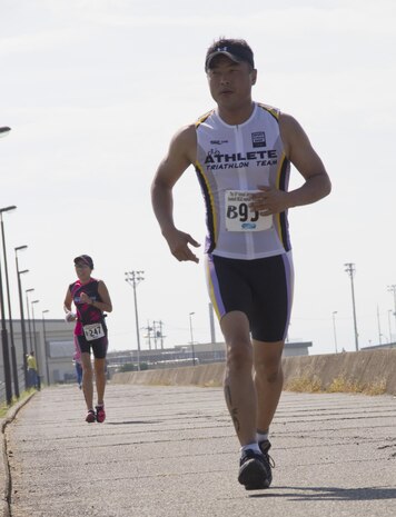 Tstuomu Morimoto, an experienced triathlon competitor, overtakes another triathlon competitor, during the Marine Corps Community Services Iwakuni Modified Triathlon here Sunday.