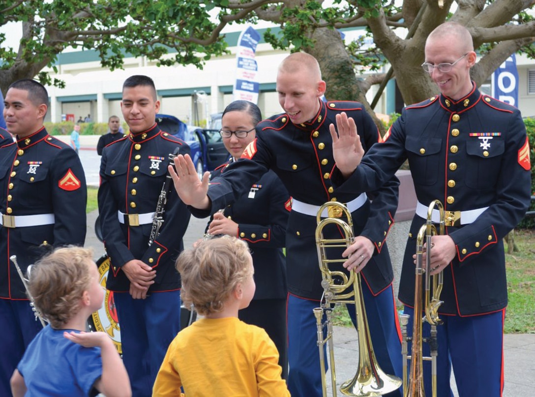 Pictured here before their promotions, Sergeants Wayne Geary, second from right, and John Geary high-five another set of twins following a III Marine Expeditionary Force Band concert in 2012. The Gearys are members of the III MEF Band. 