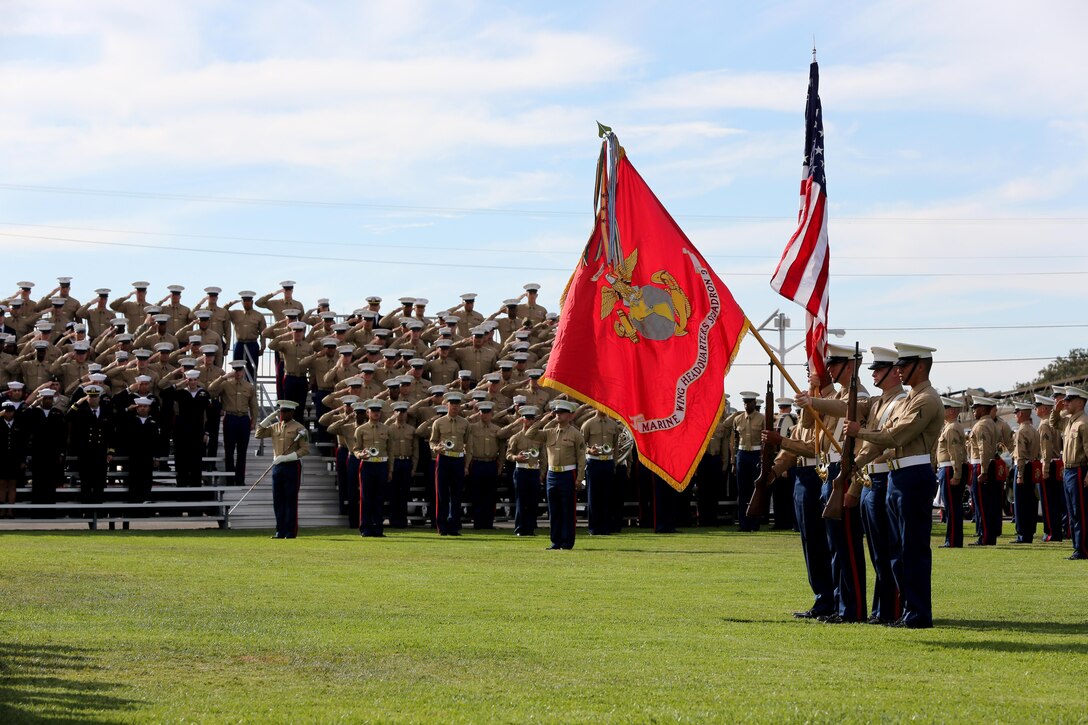 Marines stand and salute the flag as the sound of colors plays during a cake cutting ceremony aboard Marine Corps Air Station Miramar, Calif., Nov. 7. Marines also participated in a motivational birthday run earlier the same morning.
