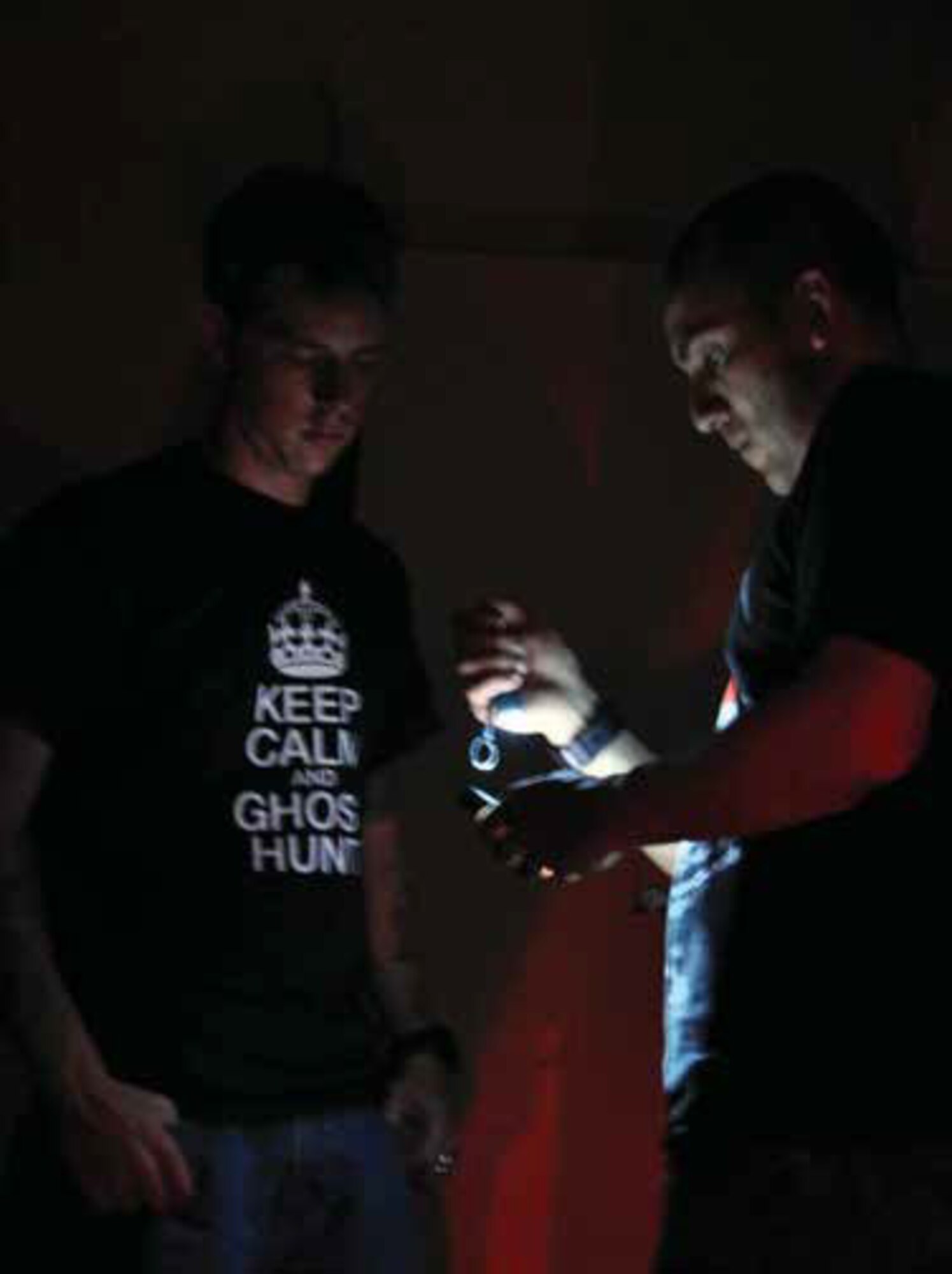 Senior Airman Mathieu Beaulieu, 912th Air Refueling Squadron (left) and Senior Airman Jose Mora, 452nd Aerospace Medicine Squadron, prepare to set up a digital voice recorder during a September 2013 paranormal investigation at March Air Reserve Base, Calif. Beaulieu, an active duty mechanic, and Mora, a Reserve medical administration technician, joined forces to investigate various locations on the historic base.(U.S. Air Force photo/Linda Welz)