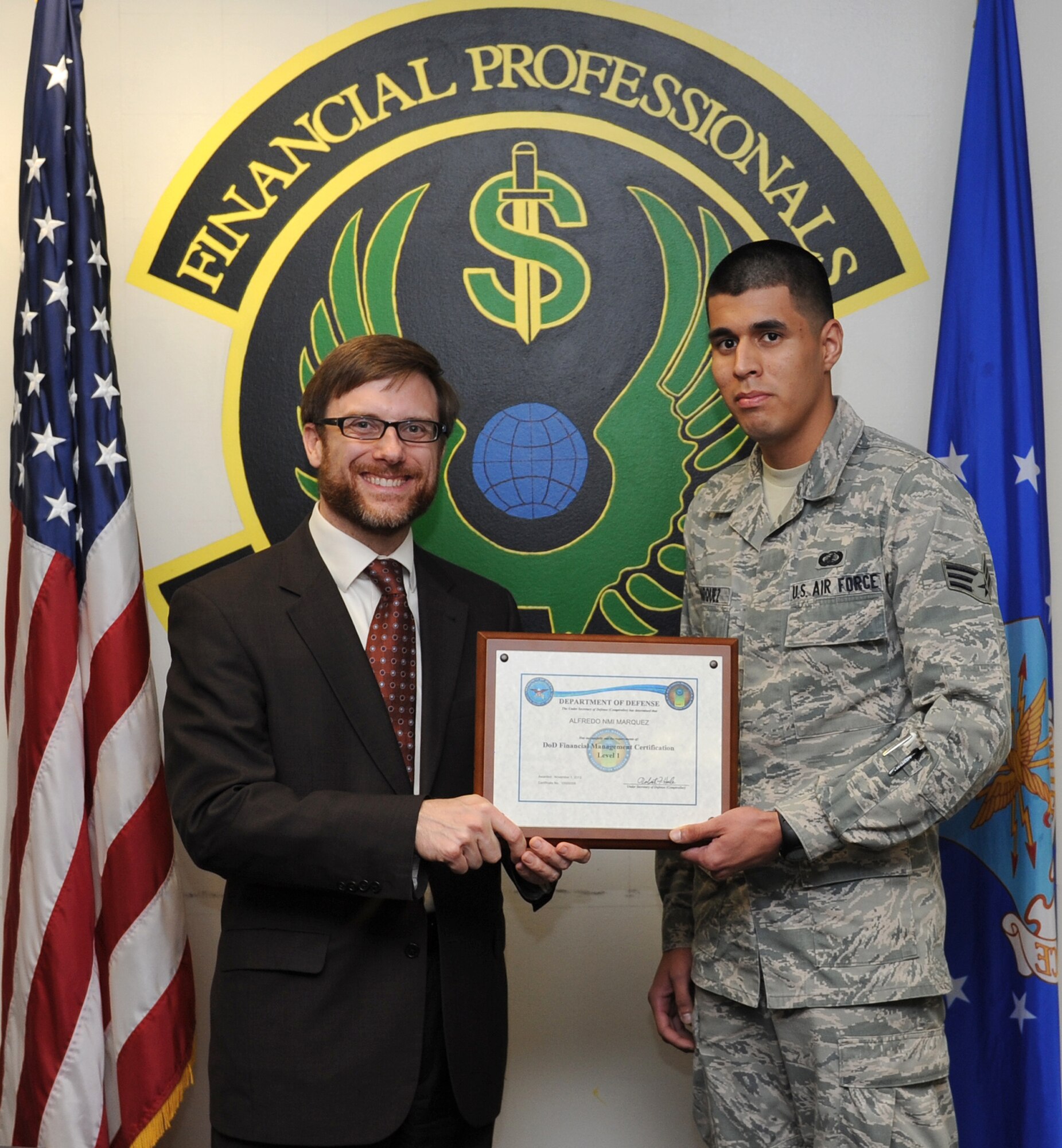 Dr. Jamie Morin, Assistant Secretary of the Air Force Financial Management comptroller, presents a Department of Defense Financial Management Program certificate to Senior Airman Alfredo Marquez, 1st Special Operations Comptroller Squadron budget analysis, during a visit at Hurlburt Field, Fla., Nov. 5. Marquez is the first Airman in the Air Force to complete the DOD program. (U.S. Air Force photo/Senior Airman Kentavist P. Brackin) 