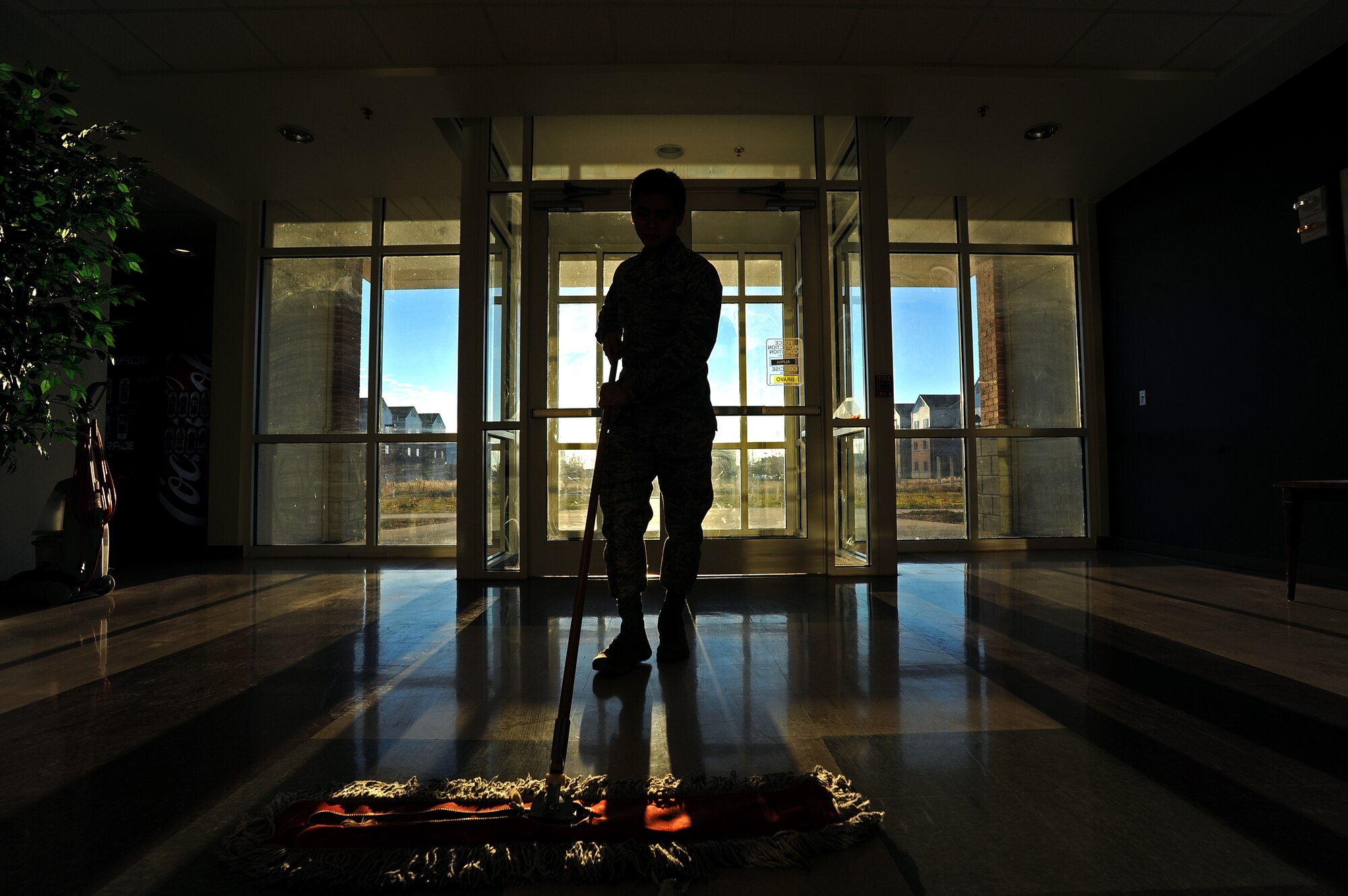 Airman 1st Class Joseph Dizon, 5th Force Support Squadron personnel customer service representative, sweeps near the entrance of Dorm 221 as part of Bay Orderly duty, Nov. 7, 2013. Dizon spent one week sweeping, mopping, vacuuming, and further detailing the entire dorm building in which he resides. (U.S. Air Force photo/Senior Airman Jose L. Hernandez)