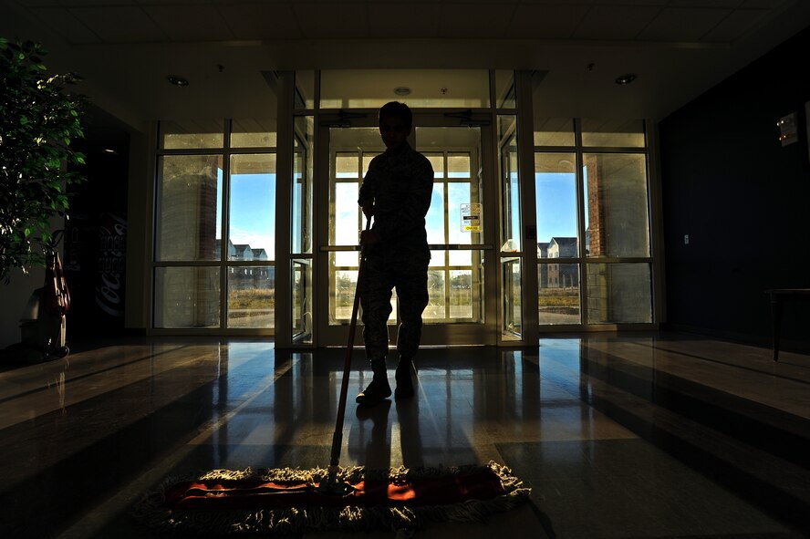 Airman 1st Class Joseph Dizon, 5th Force Support Squadron personnel customer service representative, sweeps near the entrance of Dorm 221 as part of Bay Orderly duty, Nov. 7, 2013. Dizon spent one week sweeping, mopping, vacuuming, and further detailing the entire dorm building in which he resides. (U.S. Air Force photo/Senior Airman Jose L. Hernandez)
