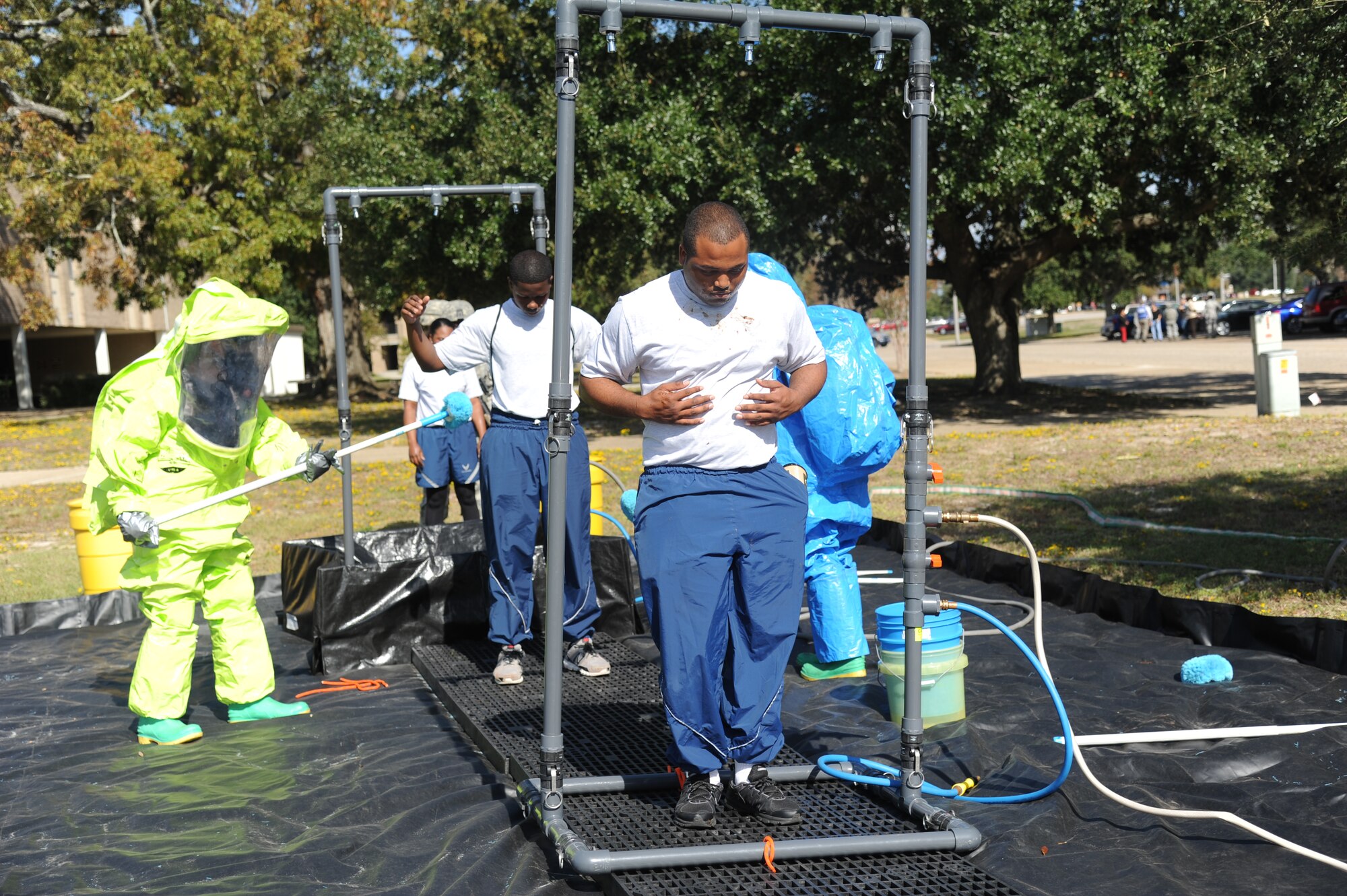 Keesler Firefighters follow decontamination procedures on Senior Airman Ladarrius Drinkard, 81st Aerospace Medicine Squadron, and Airman 1st Class Miles Walker, 81st Force Support Squadron, as they portray “victims” who were contaminated by a chemical agent during a Chemical, Biological, Radiological, Nuclear, and high-yield Explosive exercise scenario Nov. 6, 2013, at Keesler Air Force Base, Miss.  The Force Protection Condition exercise scenario included a suspect posing as a driver making a delivery to the Locker House and spraying a chemical on a group of Airmen as they were assisting him with unloading the packages from the truck.  Immediately, the Airmen simulated receiving eye irritations, excessive sweating, chest pain, choking, and vomiting from exposure to the chemical. (U.S. Air Force photo by Kemberly Groue)