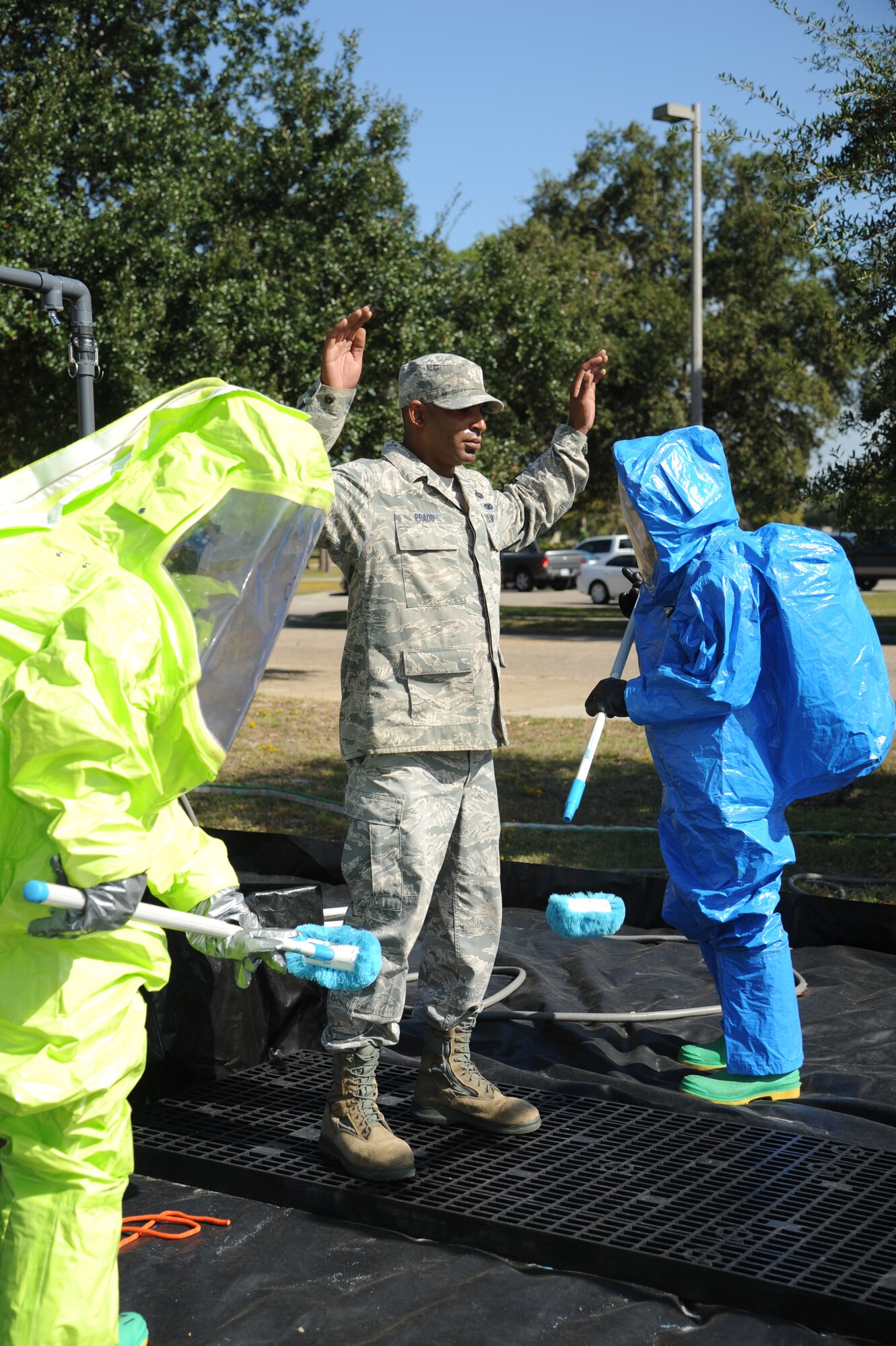 Keesler Firefighters follow decontamination procedures on Tech. Sgt. Carlos Prado, 338th Training Squadron, as he portrays a “victim” who was contaminated by a chemical agent during a Chemical, Biological, Radiological, Nuclear, and high-yield Explosive exercise scenario Nov. 6, 2013,  at Keesler Air Force Base, Miss.  The Force Protection Condition exercise scenario included a suspect posing as a driver making a delivery to the Locker House and spraying a chemical on a group of Airmen as they were assisting him with unloading the packages from the truck.  Immediately, the Airmen simulated receiving eye irritations, excessive sweating, chest pain, choking, and vomiting from exposure to the chemical. (U.S. Air Force photo by Kemberly Groue)