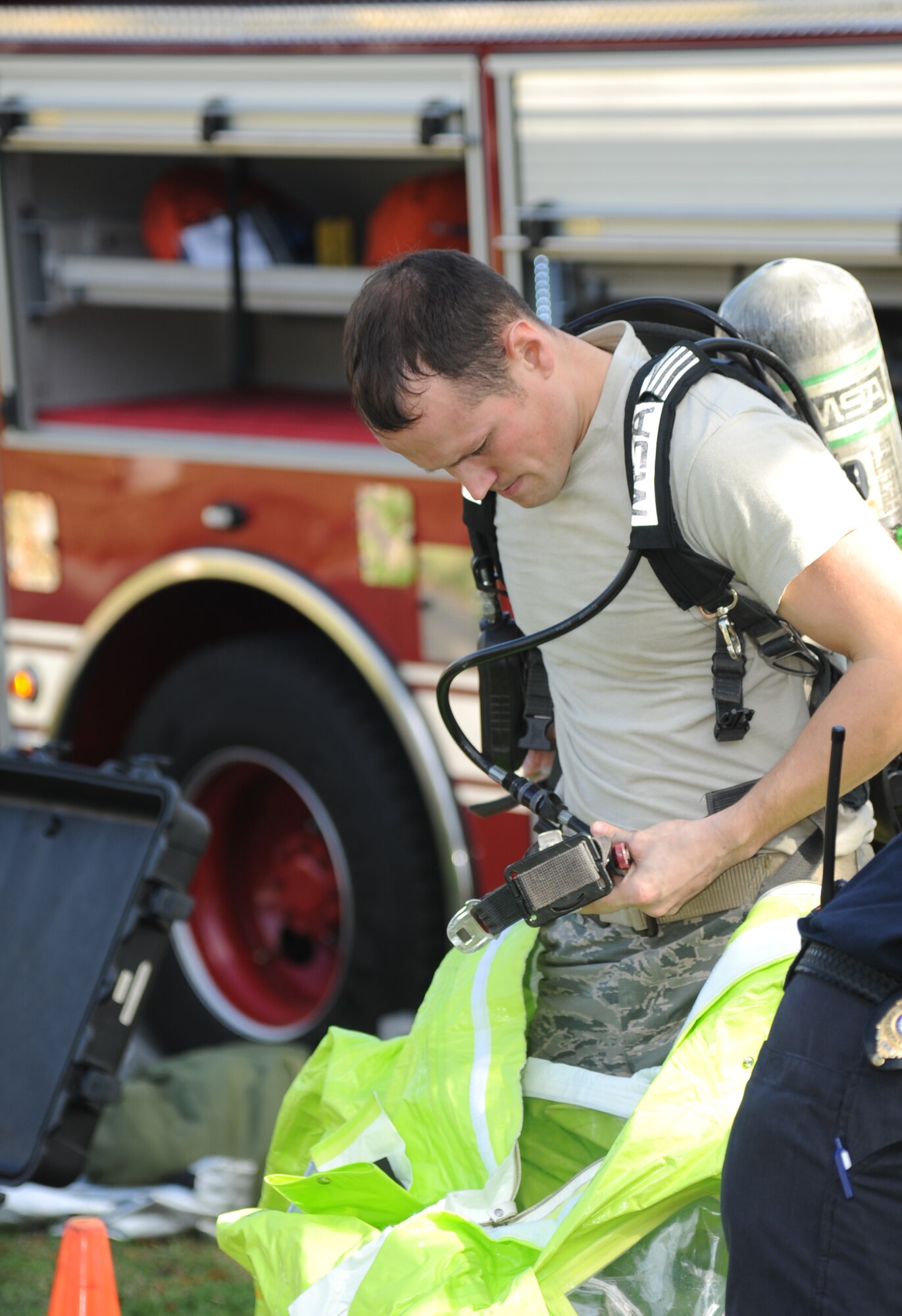 Senior Airman Christopher Lecomte, Keesler firefighter, dresses into a protective level-A suit for entry into the contamination zone during a Chemical, Biological, Radiological, Nuclear, and high-yield Explosive exercise scenario Nov. 6, 2013, at Keesler Air Force Base, Miss.  The Force Protection Condition exercise scenario included a suspect posing as a driver making a delivery to the Locker House and spraying a chemical on a group of Airmen as they were assisting him with unloading the packages from the truck.  Immediately, the Airmen simulated receiving eye irritations, excessive sweating, chest pain, choking, and vomiting from exposure to the chemical. (U.S. Air Force photo by Kemberly Groue)