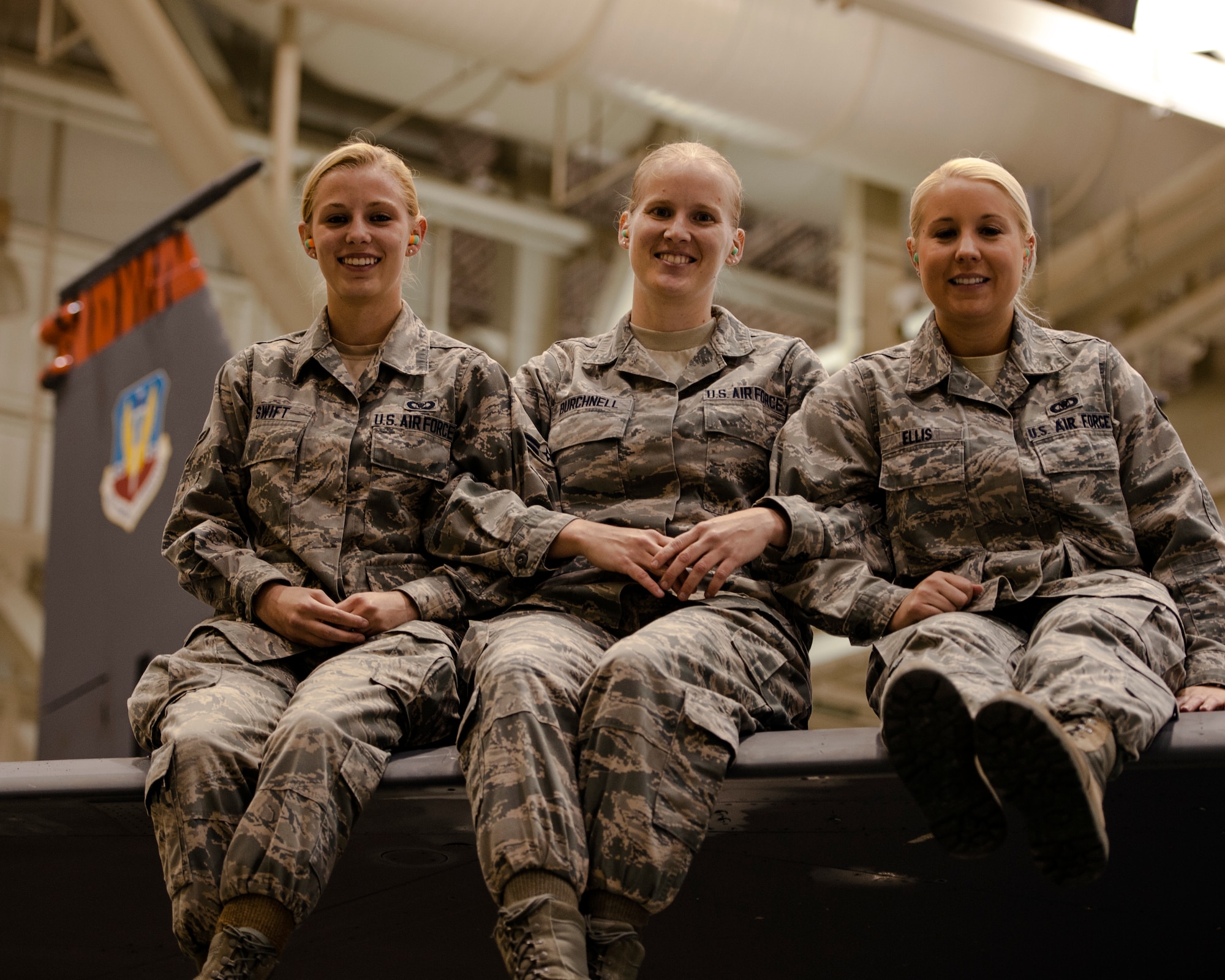 Airman 1st Class Gabrielle Swift, Airman 1st Class Rachel Burchnell and Senior Airman Jamie Ellis, 366th Operations Support Squadron Airmen, gather in a maintenance hangar at Mountain Home Air Force Base, Idaho, Nov. 7, 2013, and reflect on intervening and preventing a potential sexual assault at a Boise State University football game in October. The Air Force has no tolerance for sexual assault and the Airmen used their training and Wingman concept to assist a college student who could have potential fallen victim to the crime. (U.S. Air Force photo by Master Sgt. Kevin Wallace/RELEASED)