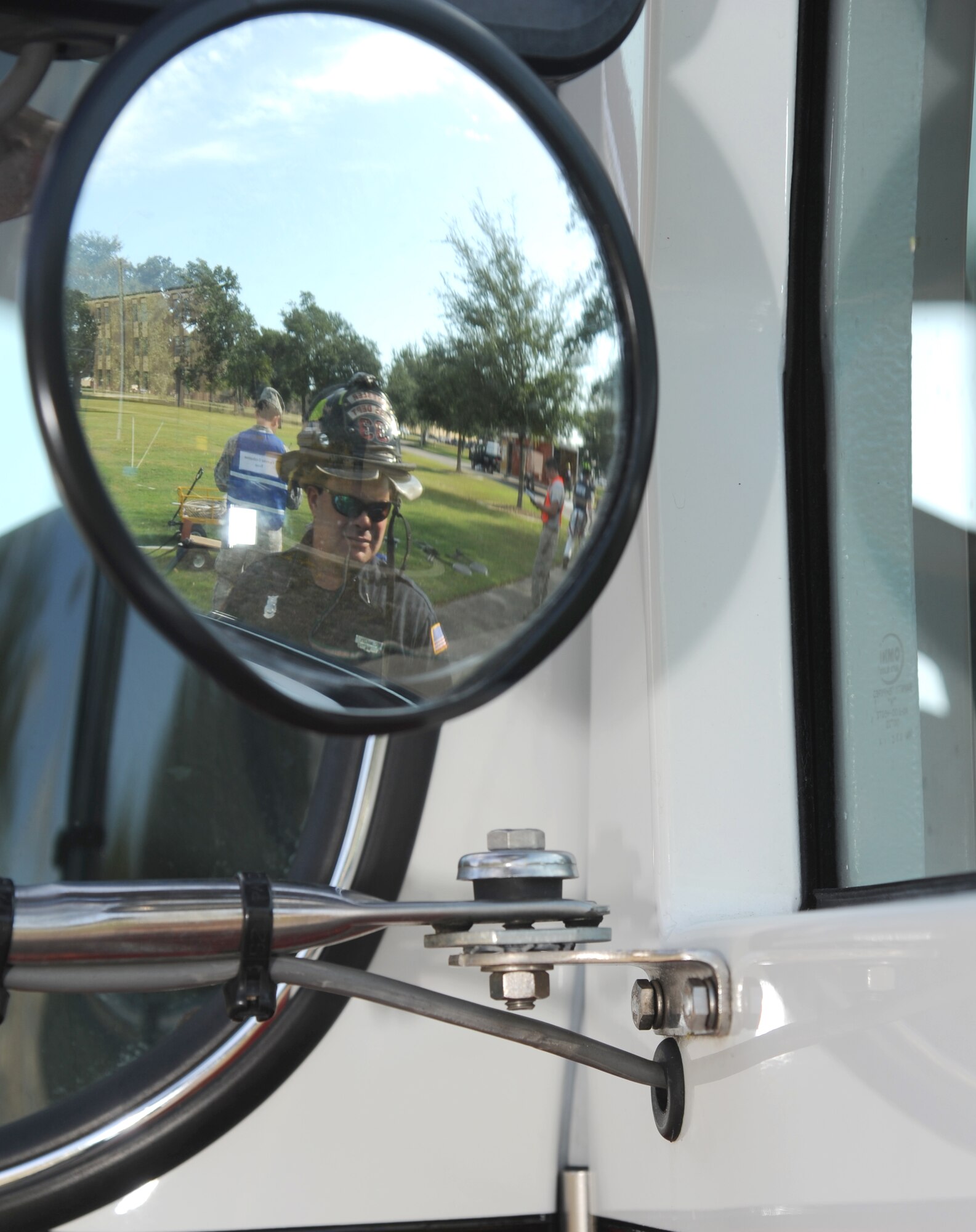 Chad Martin, Keesler firefighter, approaches a fire truck on scene during a Chemical, Biological, Radiological, Nuclear, and high-yield Explosive exercise scenario Nov. 6, 2013, at Keesler Air Force Base, Miss.  The Force Protection Condition exercise scenario included a suspect posing as a driver making a delivery to the Locker House and spraying a chemical on a group of Airmen as they were assisting him with unloading the packages from the truck.  Immediately, the Airmen simulated receiving eye irritations, excessive sweating, chest pain, choking, and vomiting from exposure to the chemical. (U.S. Air Force photo by Kemberly Groue)