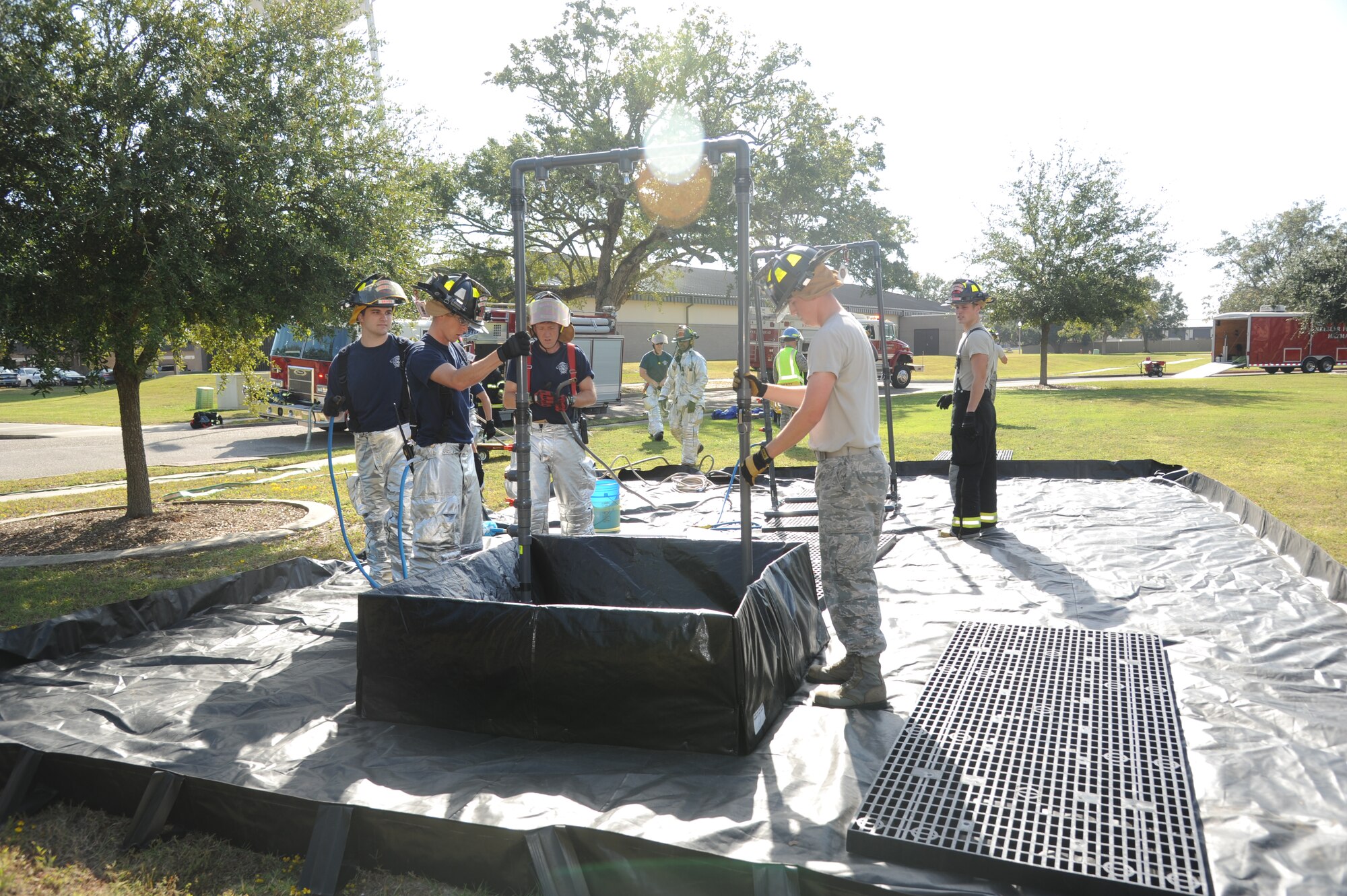 Members of the Keesler Fire Department assemble HAZMAT equipment for a decontamination site during a Chemical, Biological, Radiological, Nuclear, and high-yield Explosive exercise scenario Nov. 6, 2013, at Keesler Air Force Base, Miss.  The Force Protection Condition exercise scenario included a suspect posing as a driver making a delivery to the Locker House and spraying a chemical on a group of Airmen as they were assisting him with unloading the packages from the truck.  Immediately, the Airmen simulated receiving eye irritations, excessive sweating, chest pain, choking, and vomiting from exposure to the chemical.  (U.S. Air Force photo by Kemberly Groue)