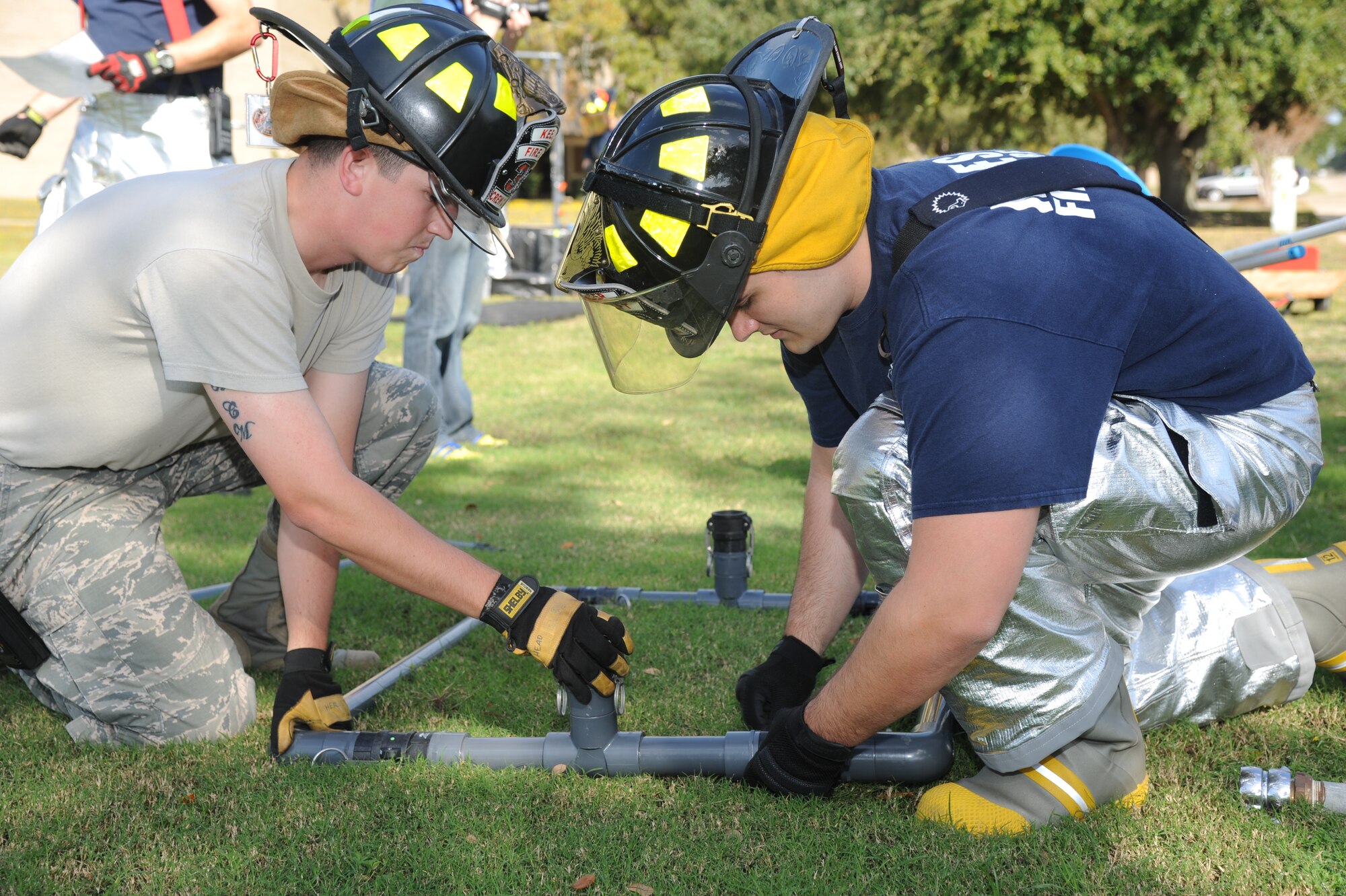 Staff Sgt. Chase Headrick and Airman 1st Class Chase, Keesler firefighters, assemble HAZMAT equipment for a decontamination site during a Chemical, Biological, Radiological, Nuclear, and high-yield Explosive exercise scenario Nov. 6, 2013, at Keesler Air Force Base, Miss.  The Force Protection Condition exercise scenario included a suspect posing as a driver making a delivery to the Locker House and spraying a chemical on a group of Airmen as they were assisting him with unloading the packages from the truck.  Immediately, the Airmen simulated receiving eye irritations, excessive sweating, chest pain, choking, and vomiting from exposure to the chemical.  (U.S. Air Force photo by Kemberly Groue)