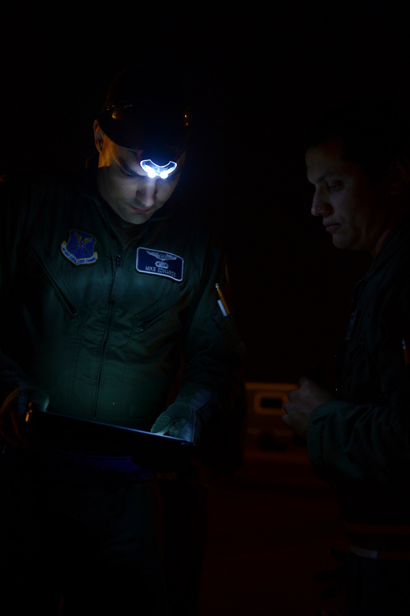 Capts. Michael Edwards and Christopher Swope, 20th Bomb Squadron aircrew, look at a checklist on Barksdale Air Force Base, La., Oct. 29, 2013. Edwards and Swope, along with their fellow aircrew, made a simulated emergency landing in an isolated area. The crew had to inspect the aircraft and fix any discrepancies themselves. (U.S. Air Force photo/Senior Airman Micaiah Anthony)
