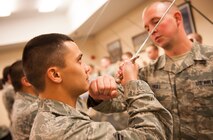 Staff Sgt. Joshua Hull, 5th Force Support Squadron installation Honor Guard Non Commissioned Officer in charge, perfects an Airman’s technique during Honor Guard practice at Minot Air Force Base, N.D., Nov. 6, 2013. Hull spends time every week training Airmen on the proper ceremonial drill moves. (U.S. Air Force photo/Airman 1st Class Apryl Hall)