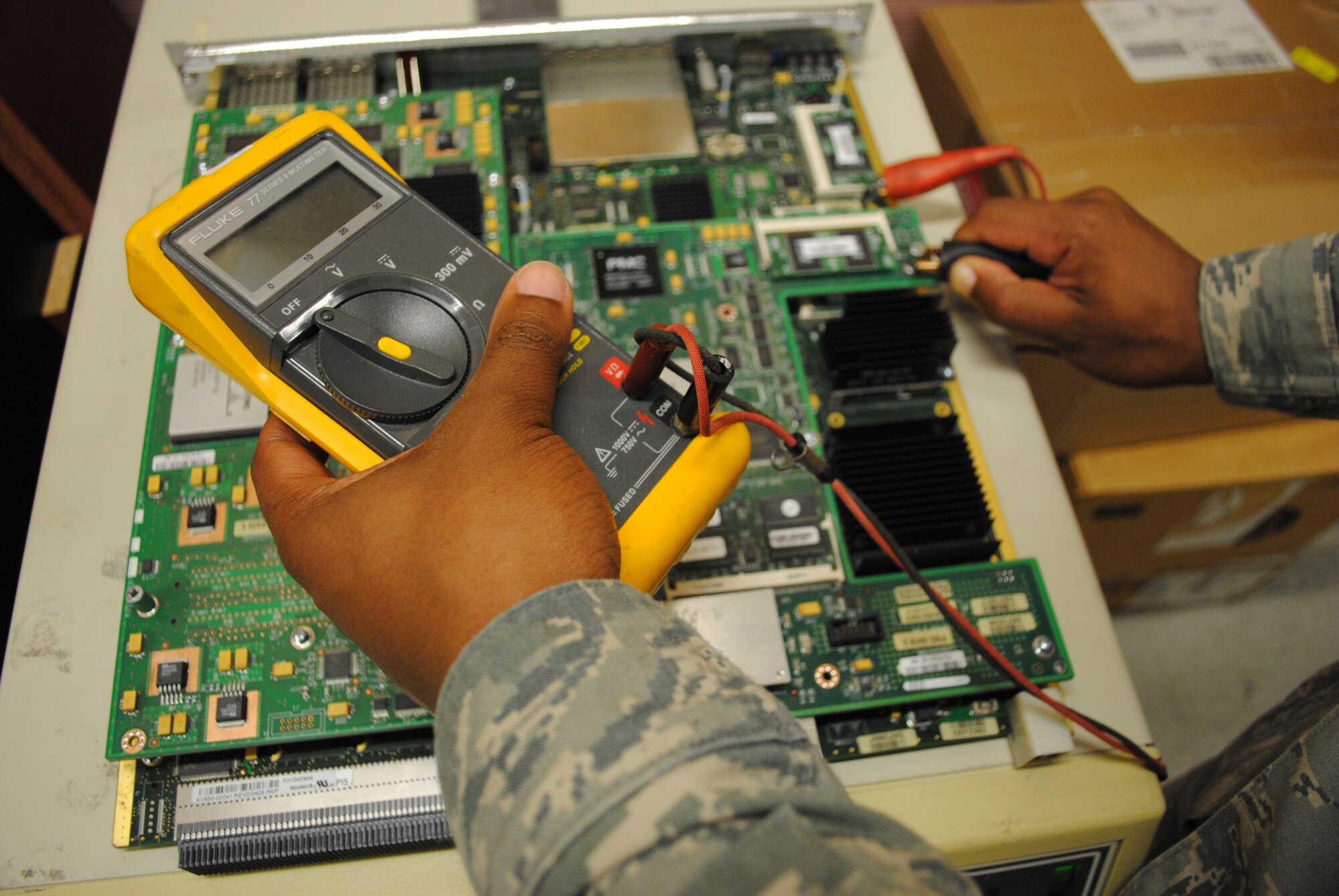 Airman 1st Class Xavier Love, 319th Communications Squadron, uses a multi-meter to detect the presence of electricity running through various components of a computer circuit board, May 30, 2013, at Grand Forks Air Force Base, N.D. Motherboards such as this one have the capability of transferring information simultaneously for up to 48 telephone lines on a computer network. (U.S. Air Force photo/Staff Sgt. Luis Loza Gutierrez)

