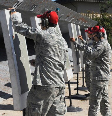 Combat arms instructions from the 1st Special Operations Security Forces Squadron evaluate targets during M9 pistol training at Hurlburt Field, Fla., Nov.5, 2013. The training is conducted regularly to qualify service members for various reasons like deployment readiness, annual certification, permanent changes in station, proficiency, and sustainment shooting. (U.S. Air Force photo/Staff Sgt. Jeff Andrejcik)