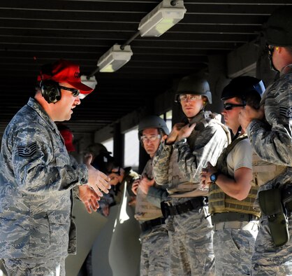 Tech. Sgt. Michael Gilbert, 1st Special Operations Security Forces Squadron assistant NCO in charge of combat arms, gives advice to students going through an M9 pistol course at Hurlburt Field, Fla., Nov. 5, 2013. Students are required to pass the course for various reasons like deployment readiness, annual certification, permanent changes in station, proficiency, and sustainment shooting. (U.S. Air Force photo/Staff Sgt. Jeff Andrejcik)
