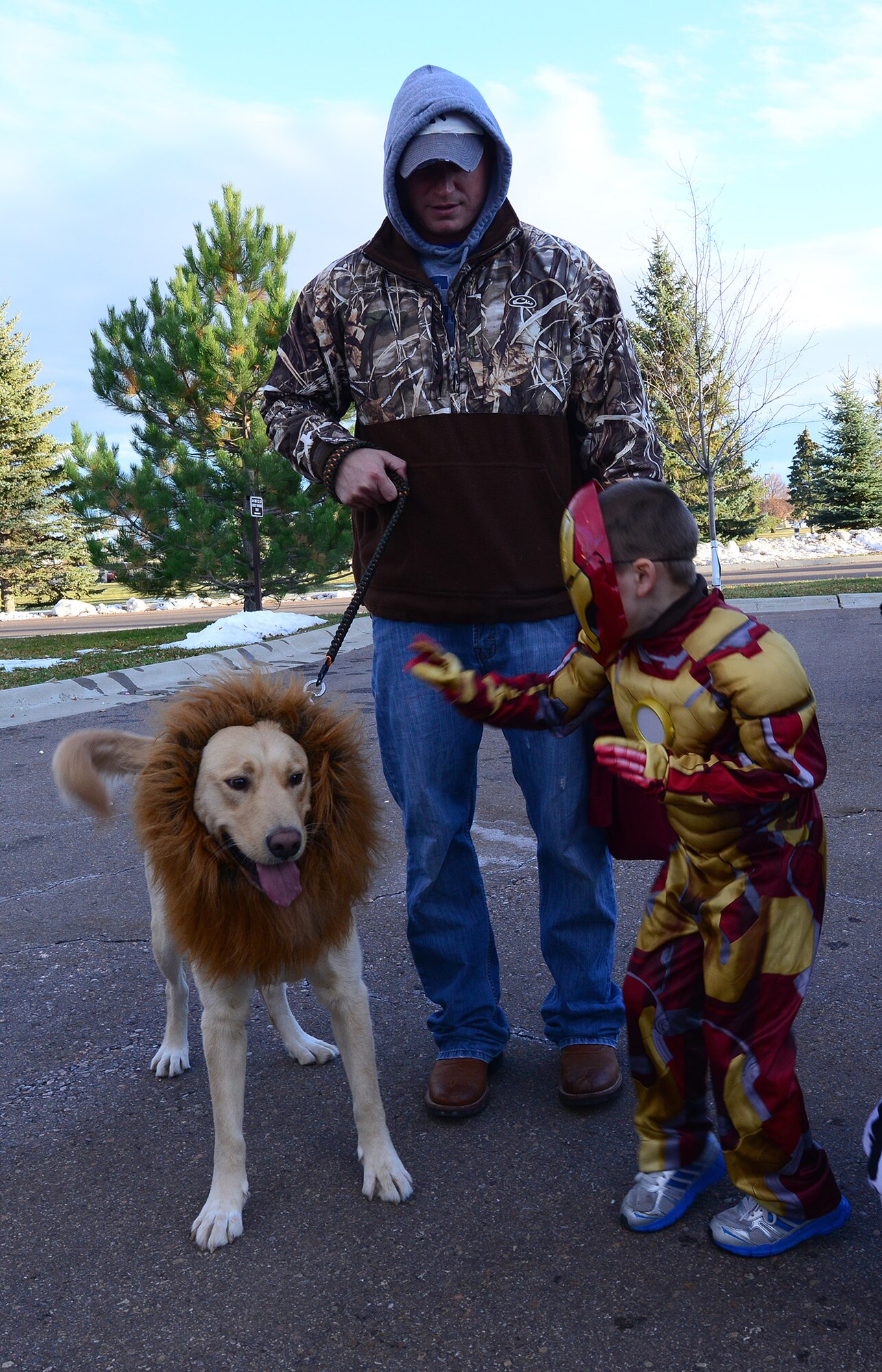 Senior Airman Corey Weaver, 819th RED HORSE Squadron airfields technician, holds a trick-or-treater dressed as Iron Man back from his lion-dog Sammy during the commanders’ Halloween party Oct. 31. Attendees of the event had the opportunity to trick-or-treat in the surrounding housing areas while enjoying free food at the Malmstrom commanders and chief master sergeants’ Halloween parties.  (U.S. Air Force photo/Airman 1st Class Collin Schmidt)