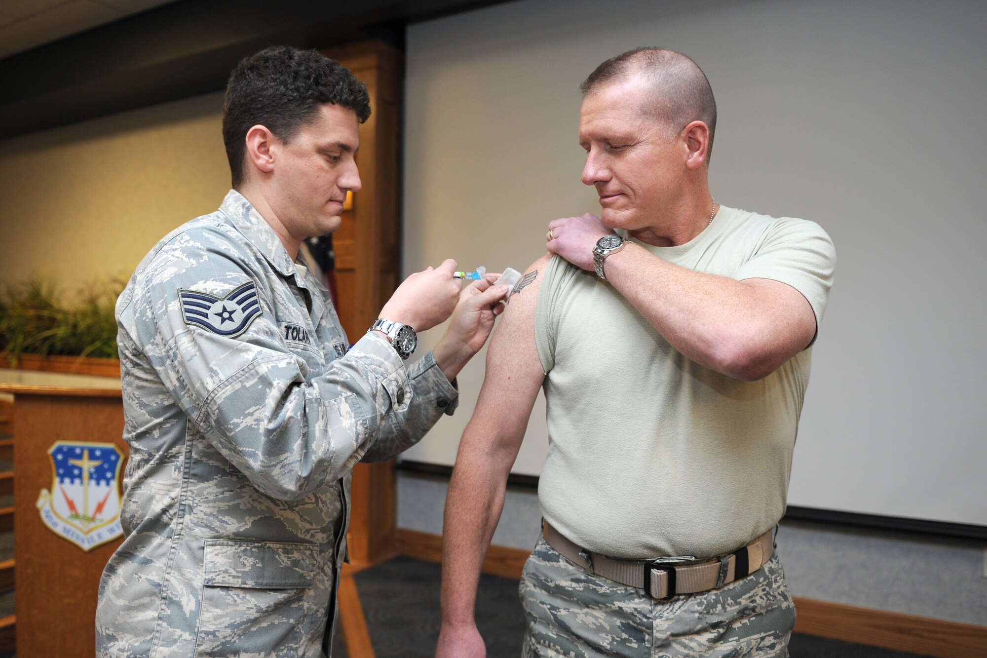 Staff Sgt. Josh Tolaro, 341st Medical Operations Squadron aerospace services technician, administers a flu shot to Col. Robert Stanley, 341st Missile Wing commander, Nov. 4. The Influenza vaccination is currently available to all active-duty Airmen on base every weekday at the immunizations clinic from 7:30 a.m. to 4 p.m. No appointments are needed. (U.S. Air Force photo/Senior Airman Katrina Heikkinen)
