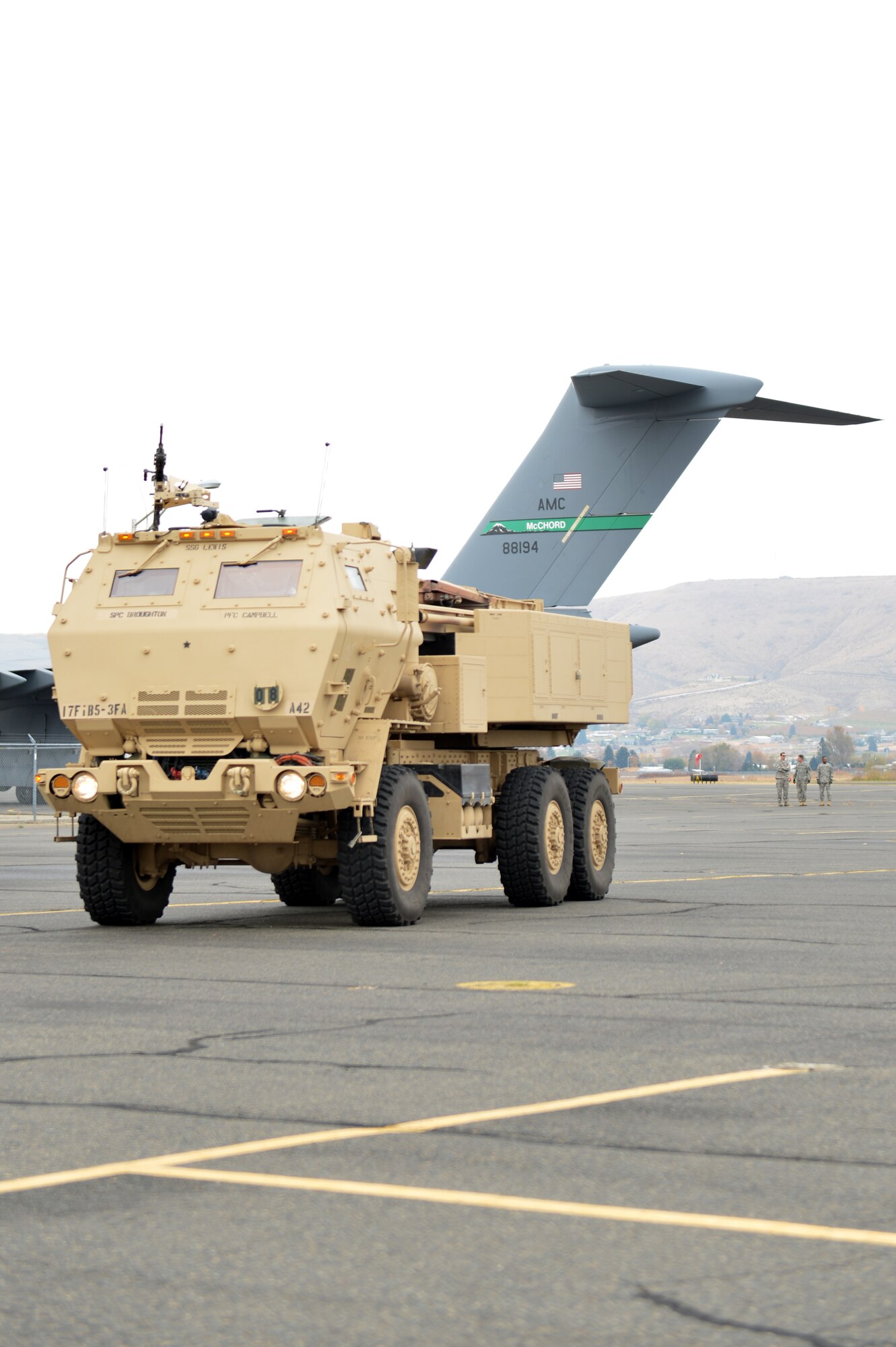 A High Mobility Artillery Rocket System vehicle is parked on the taxiway awaiting simulated firing orders after being offloaded from a C-17 Globemaster III aircraft, Nov. 5, 2013, at Moses Lake, Wash. Soldiers and Airmen from the 5th Battalion, 3rd Field Artillery and 62nd Airlift Wing at Joint Base Lewis-McChord, Wash., worked side-by-side during Operation Guy Fawkes, a joint training exercise. (U.S. Air Force photo/Staff Sgt. Jason Truskowski)